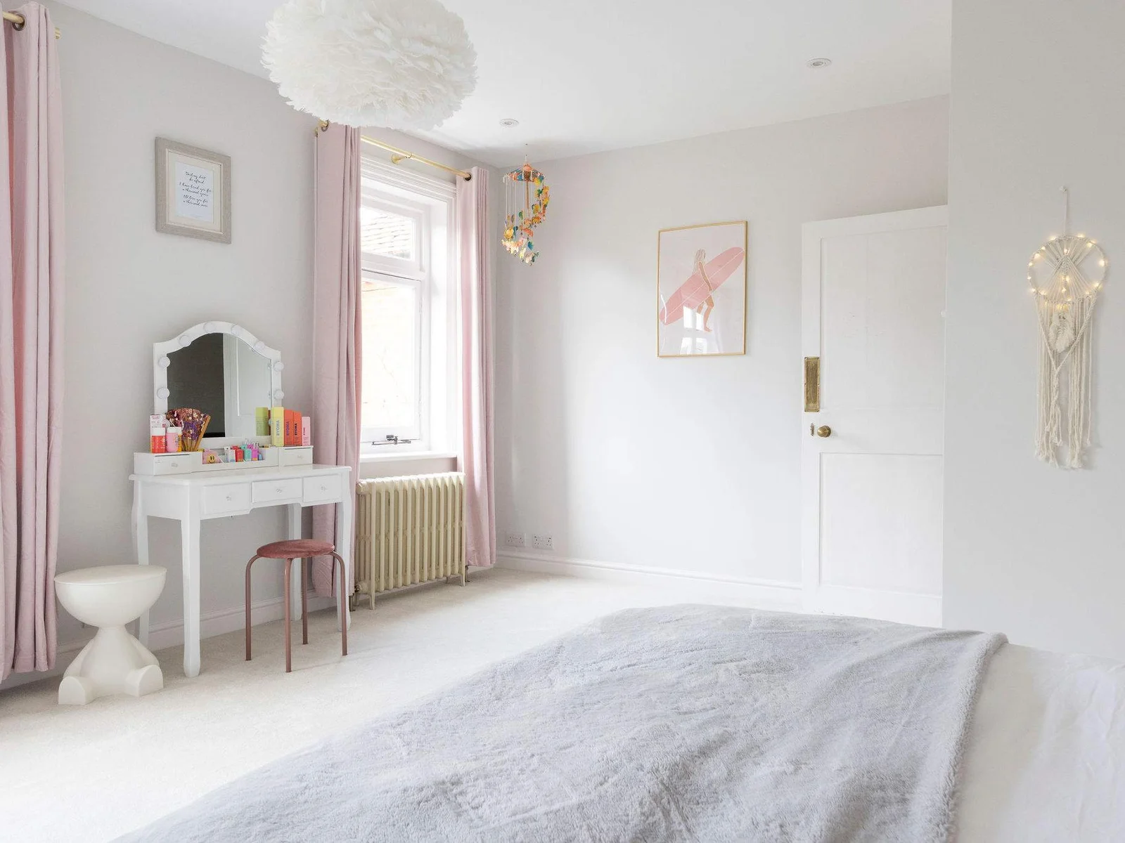 A beautifully styled bedroom with soft pastels and cosy décor