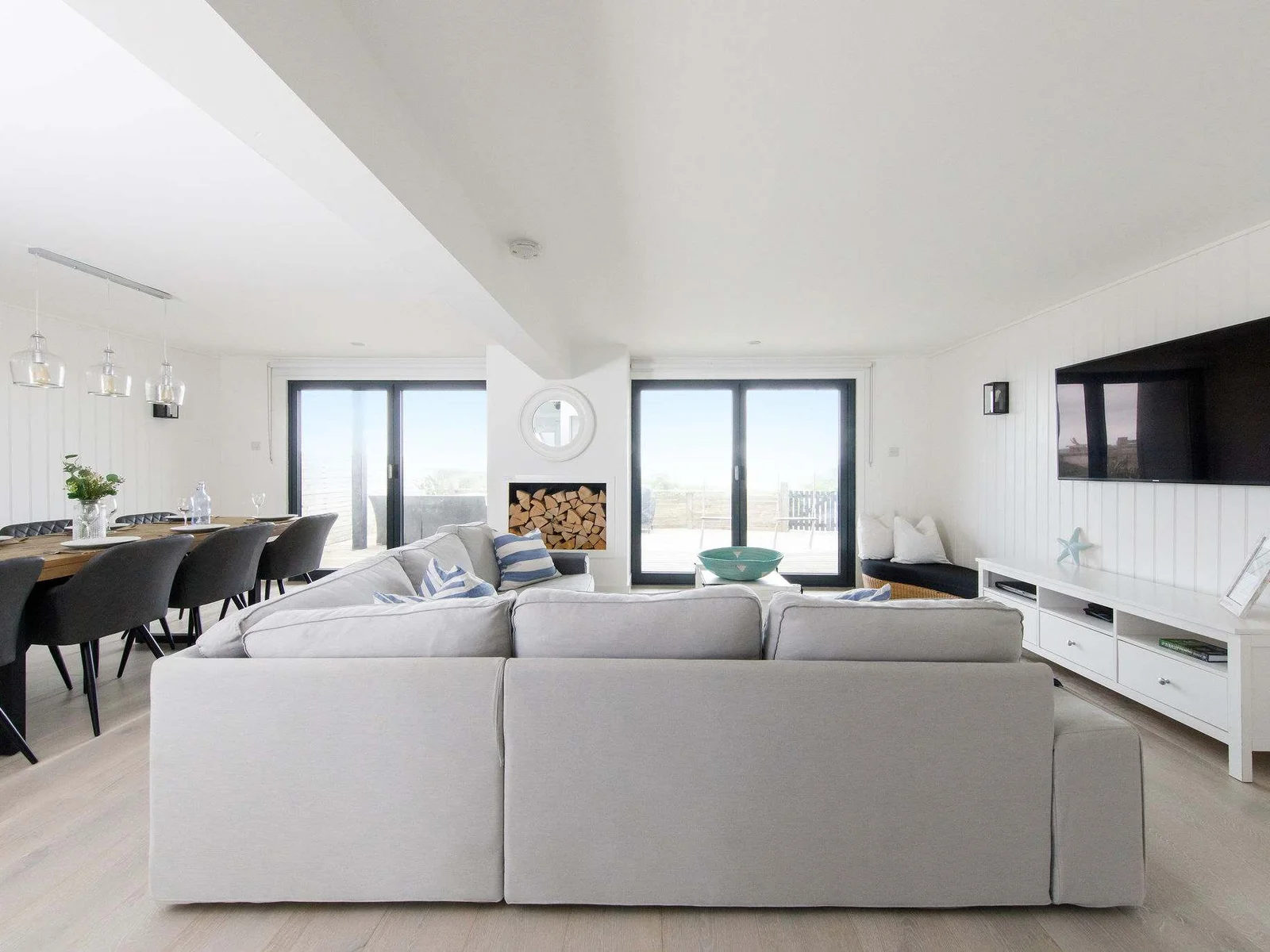 The downstairs lounge/diner with bi-fold doors out to the rear decking and beach.