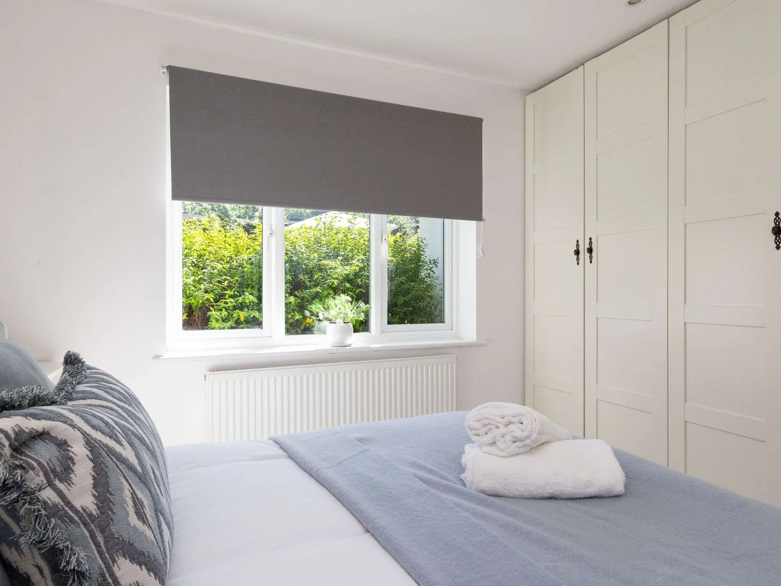 Wake up to tranquil garden views in the spacious master bedroom of our holiday home.