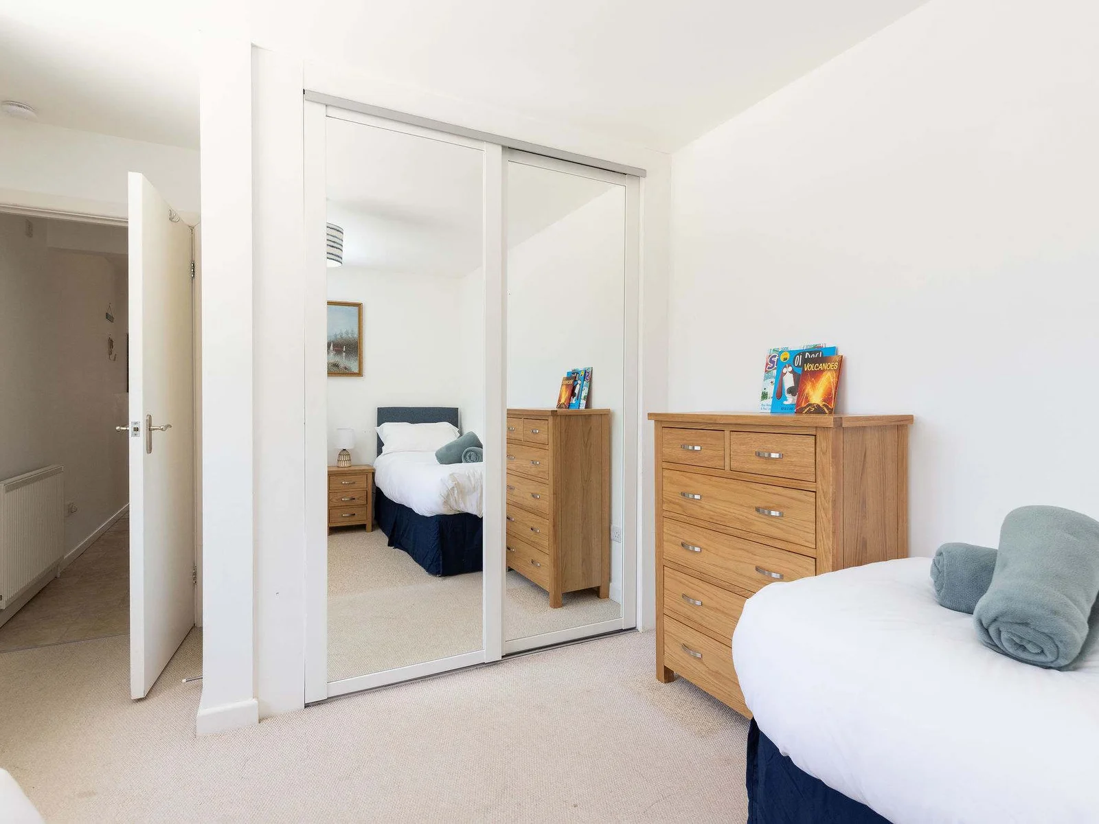 Spacious twin room with mirrored wardrobe and chest of drawers