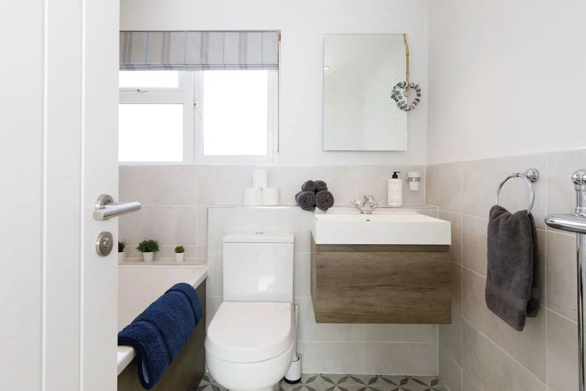 The home has a spacious and modern family bathroom stocked with fresh towels.