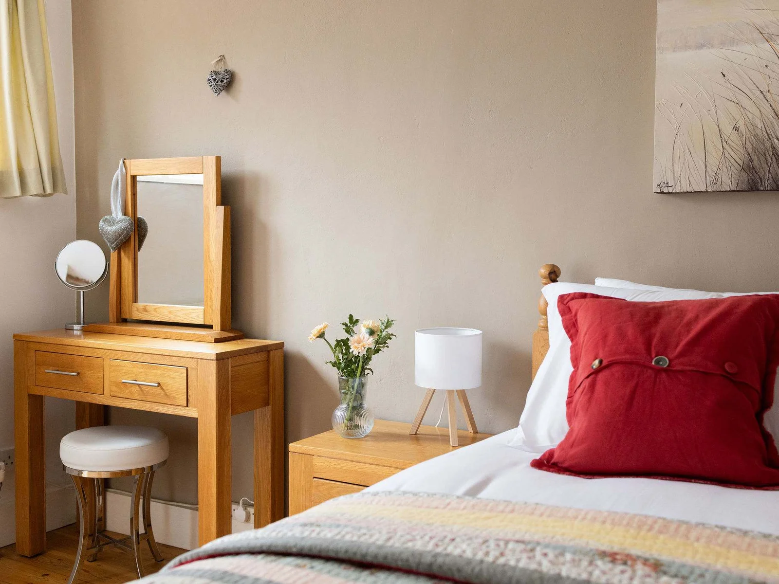 Pine dressing table with mirror and stool adds country charm in Wren Barn's master king room.