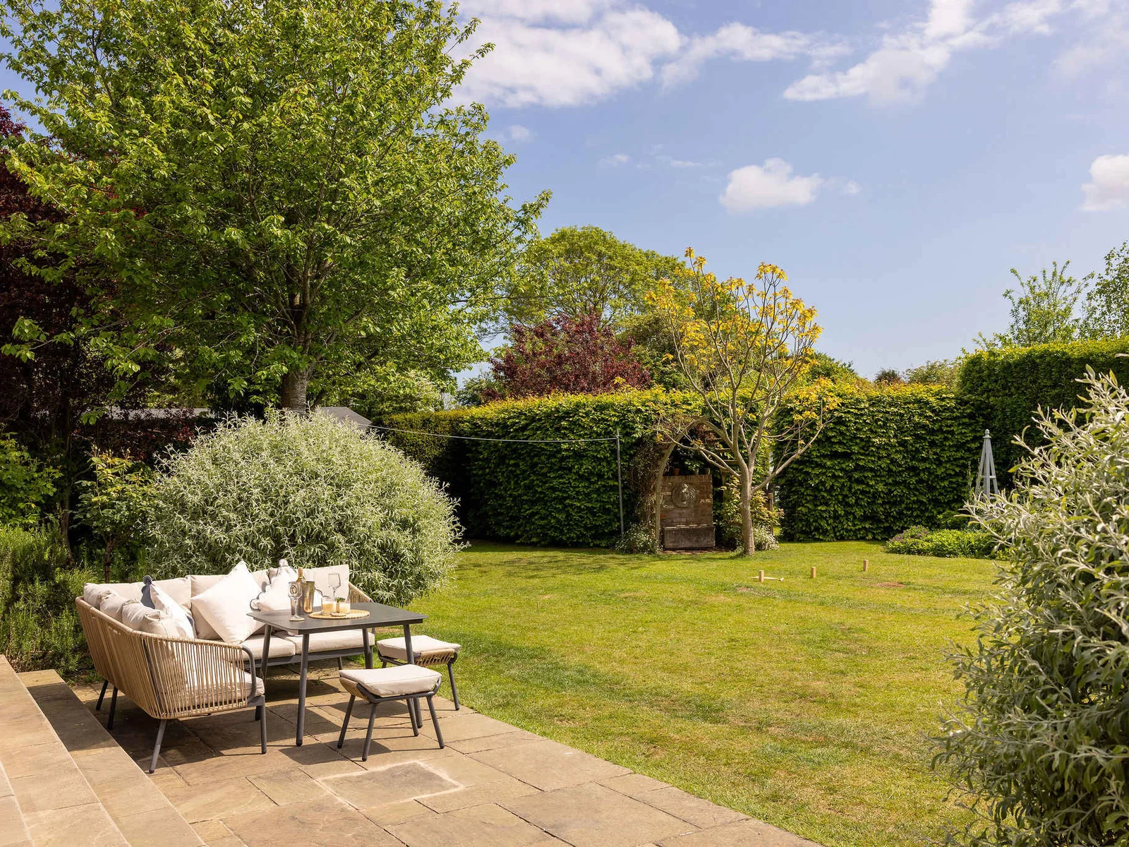 Peaceful outdoor seating area surrounded by mature gardens.