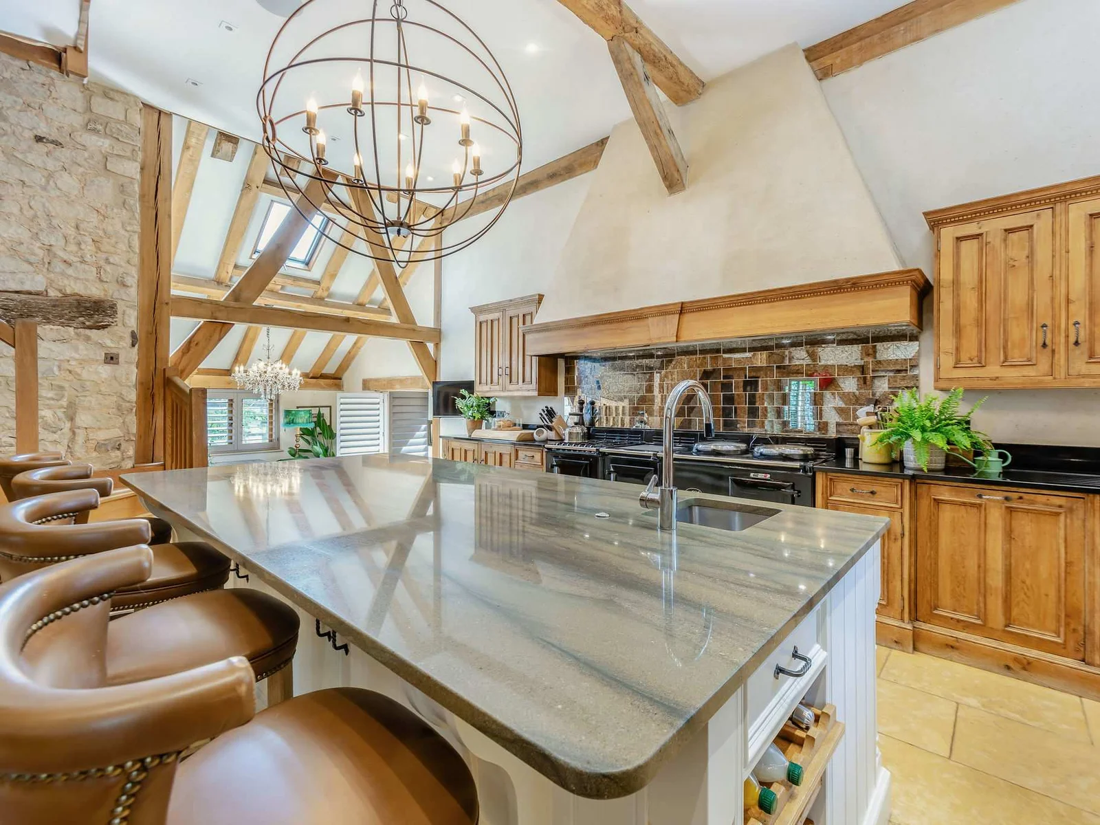 The impressive main kitchen, centred around a huge island beneath exposed beams