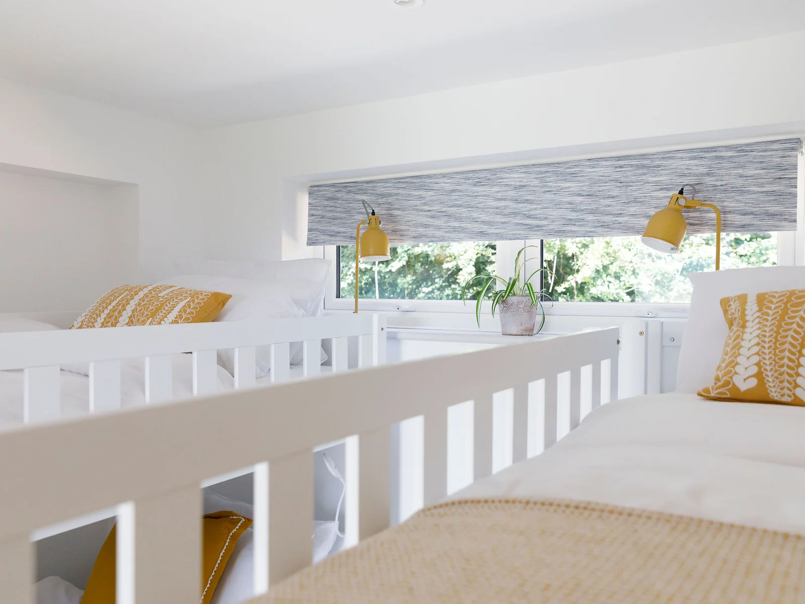 Light-filled bunk bed room with comfortable bedding and playful decor