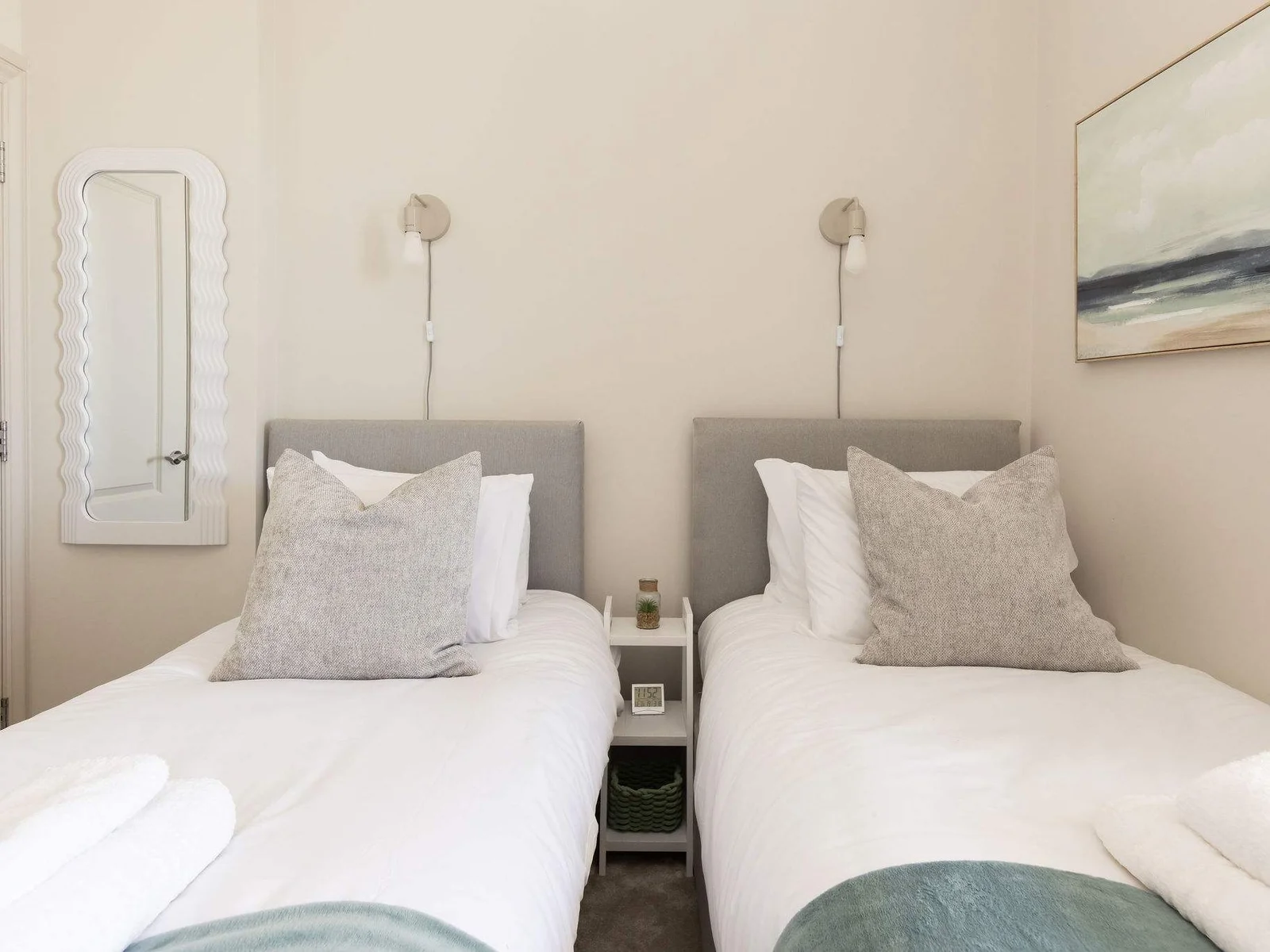 A calm and comfortable bedroom adds to the apartment’s relaxed coastal charm.