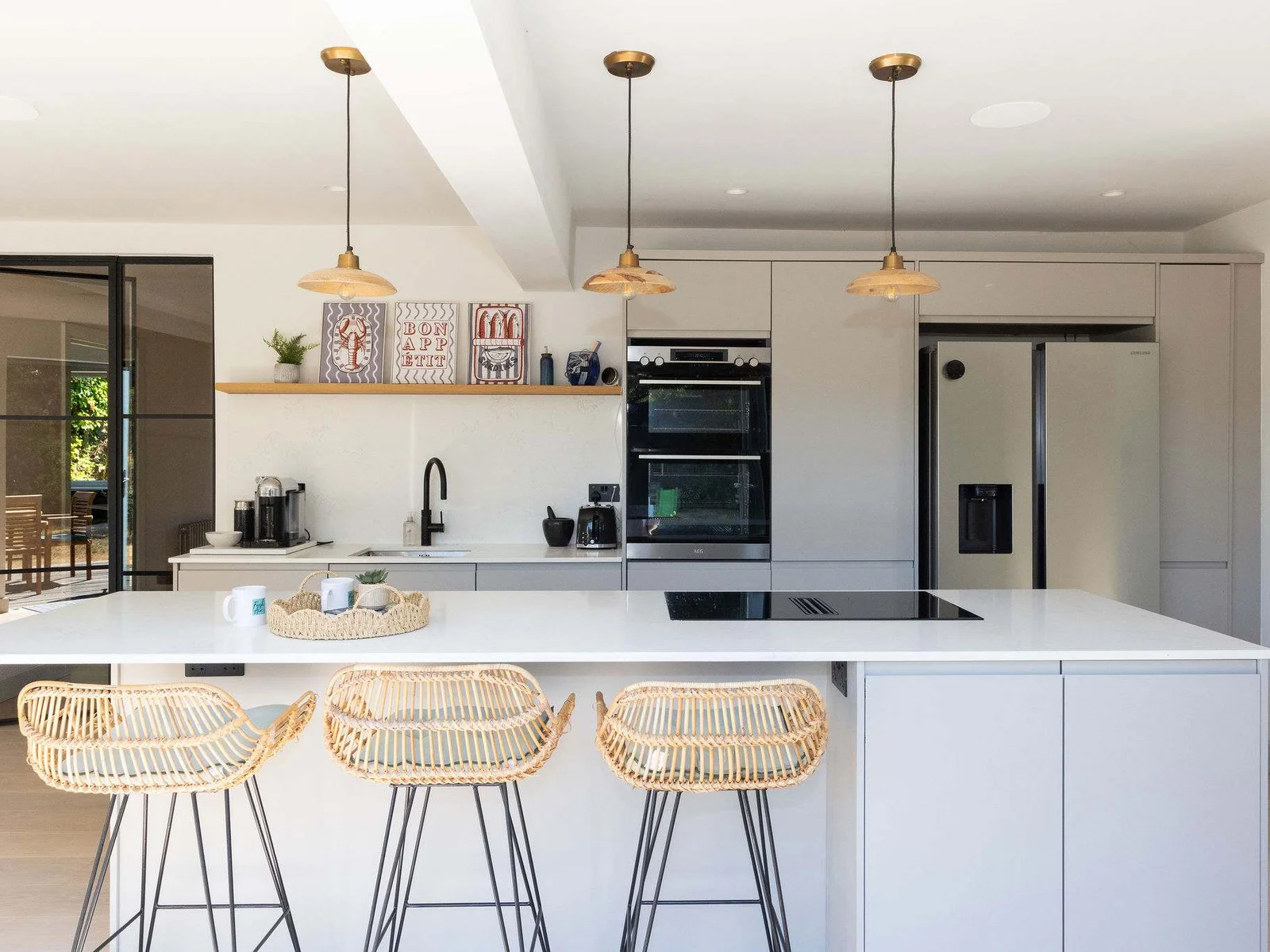 Airy, elegant and wonderfully spacious, this beautifully finished kitchen has a real sense of luxury, with a sleek white island, generous worktop space and a full range of appliances for effortless cooking and entertaining.