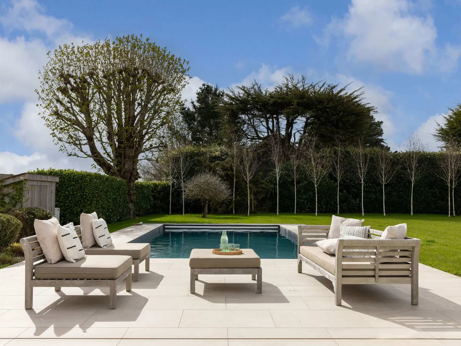 Unwind poolside with comfortable outdoor furniture, countryside views, and endless blue skies above.
