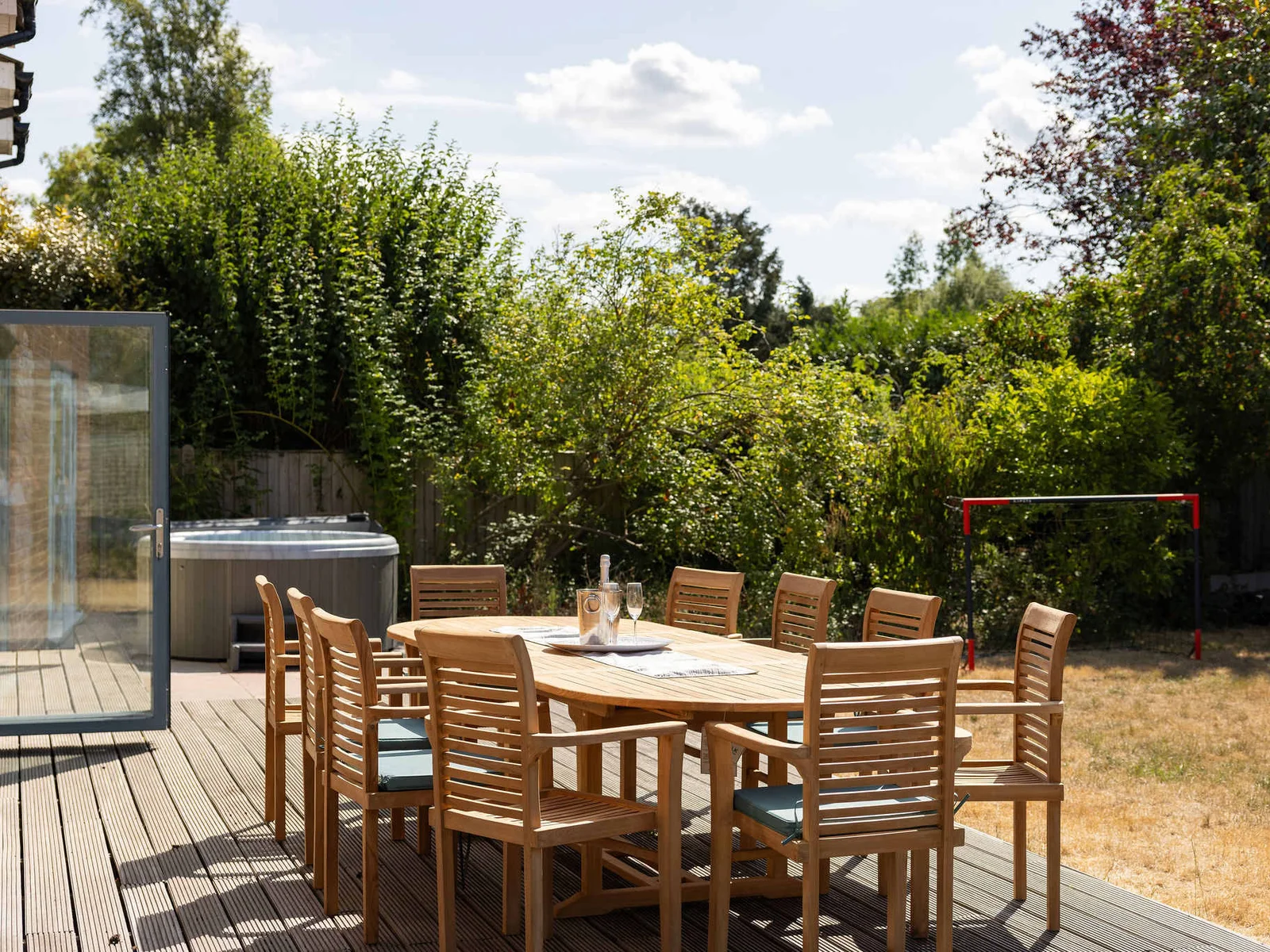 A gorgeous outdoor dining space set on the decking just outside the kitchen, with seating for up to 10 guests — perfect for long summer lunches, relaxed evening meals and drinks together, with the hot tub right alongside.
