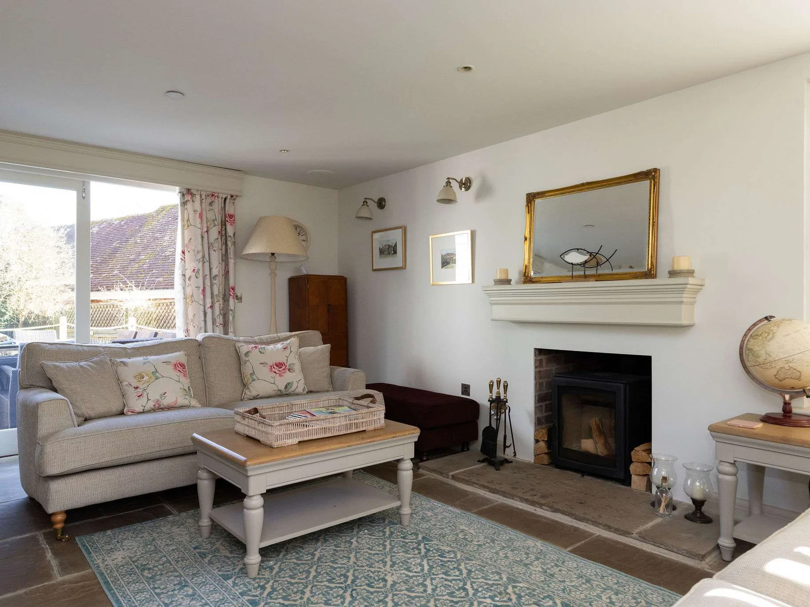 Cosy living room with wood burner and doors opening onto the garden