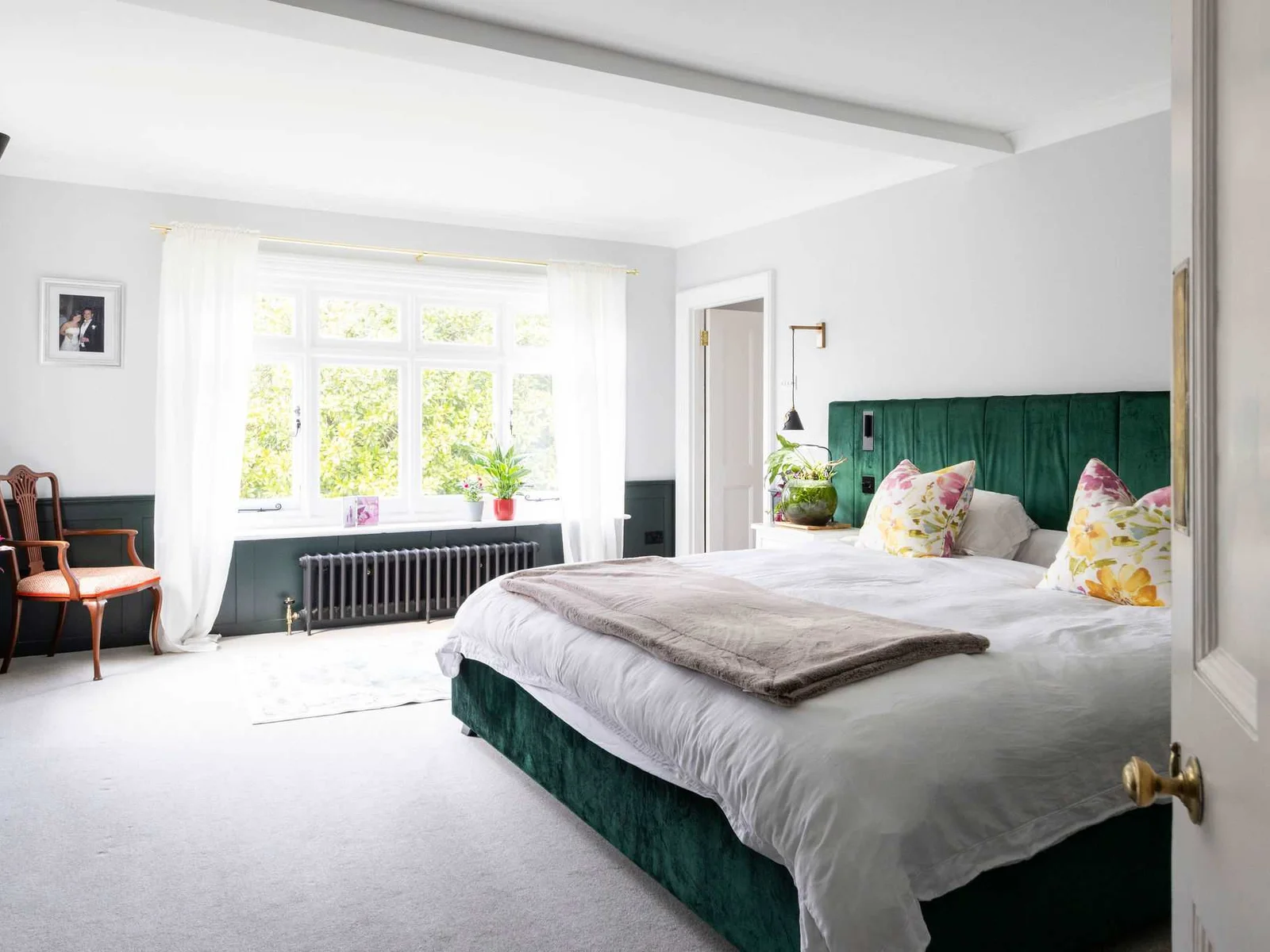 Welcome tio the elegant emperor suite featuring a plush green headboard and garden views