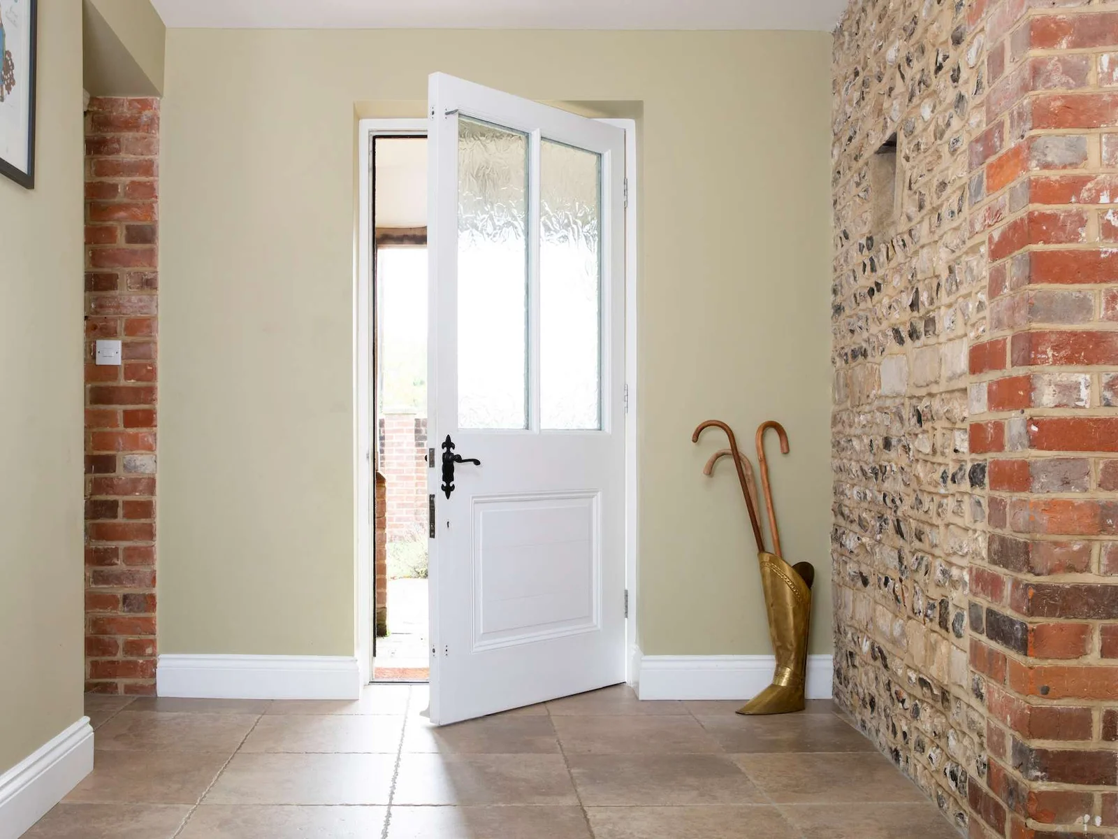 The entrance hall with stunning original brick and flint walls reclaimed from the original barn.