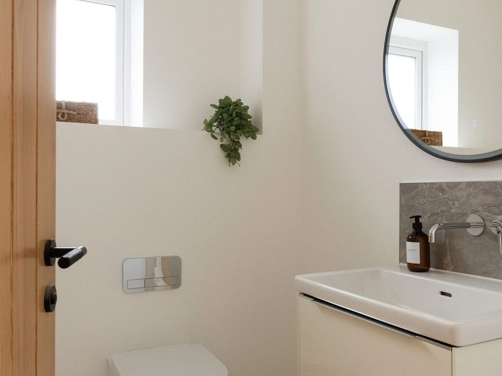 Simple modern bathroom with vanity unit and large mirror