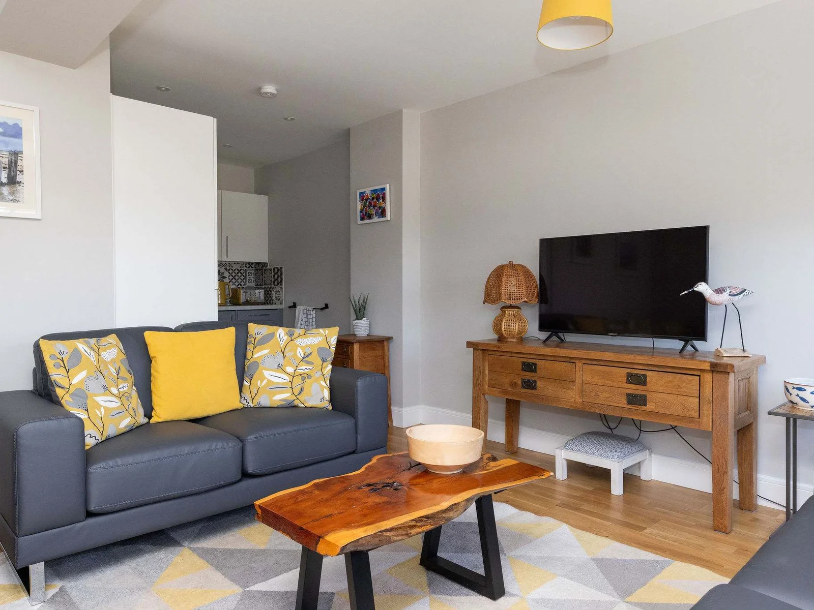 Bright open-plan lounge with comfortable seating, perfect for a relaxing coastal holiday home
