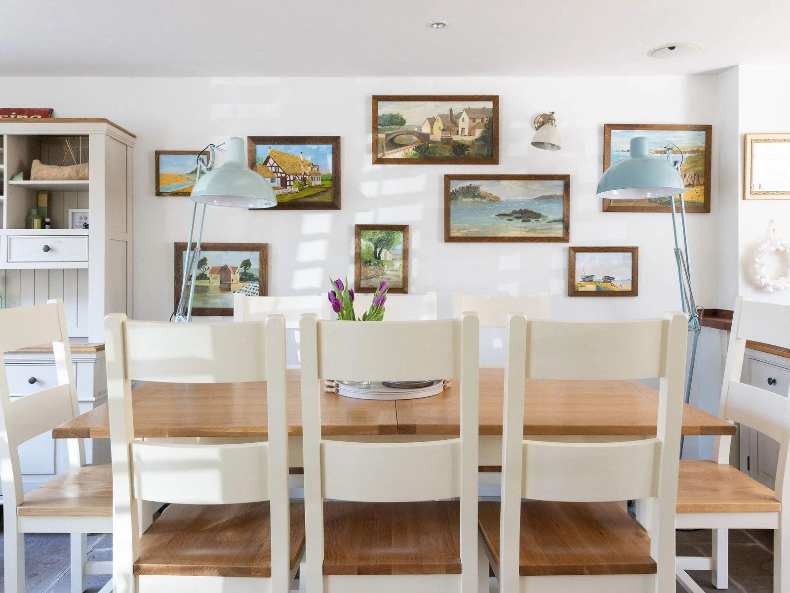 Bright dining space with coastal artwork and seating for everyone