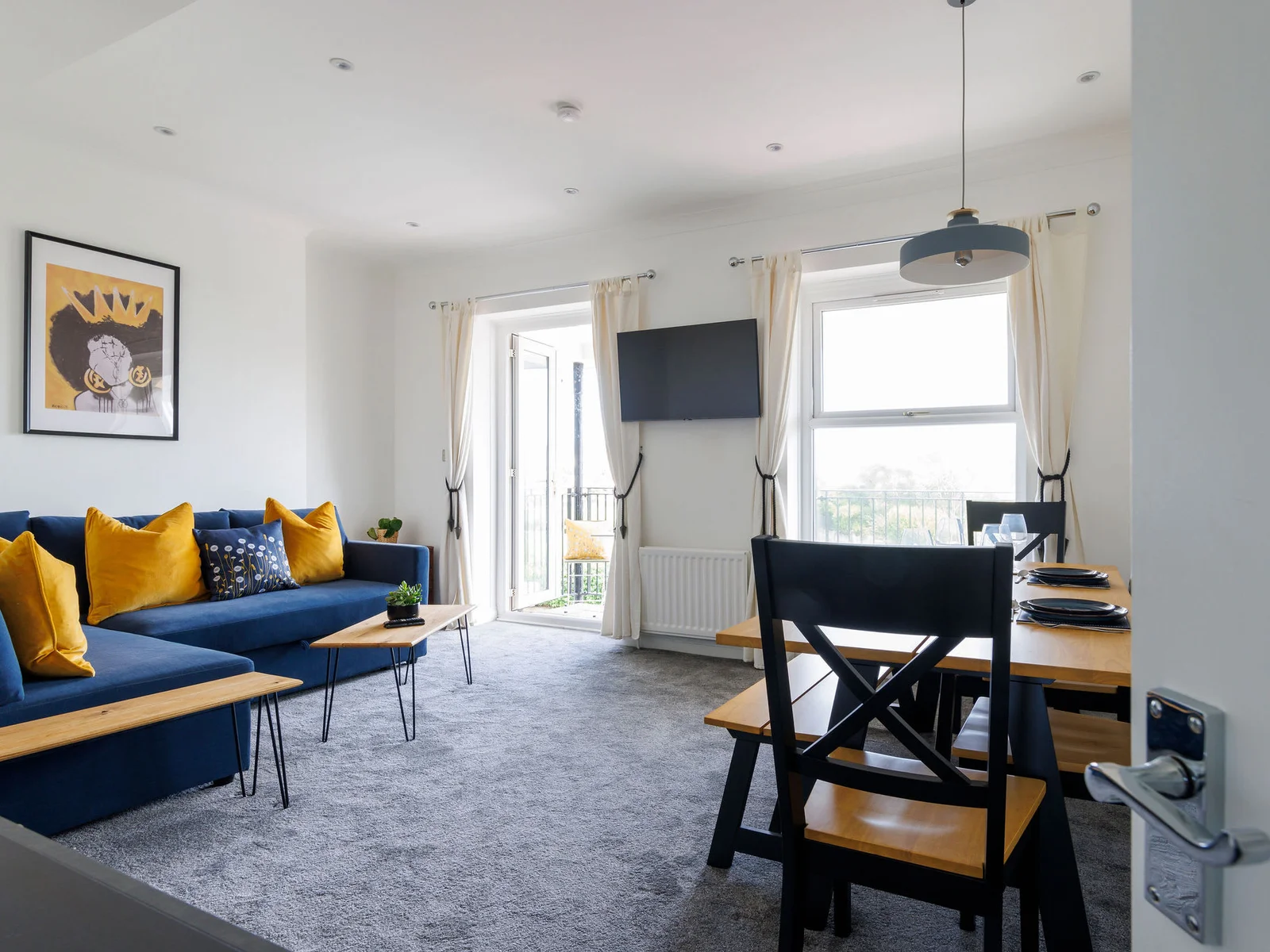 Relax in the stylish and comfortable living area, complete with plush seating, vibrant decor, and a balcony that lets in plenty of natural light and sea breeze.