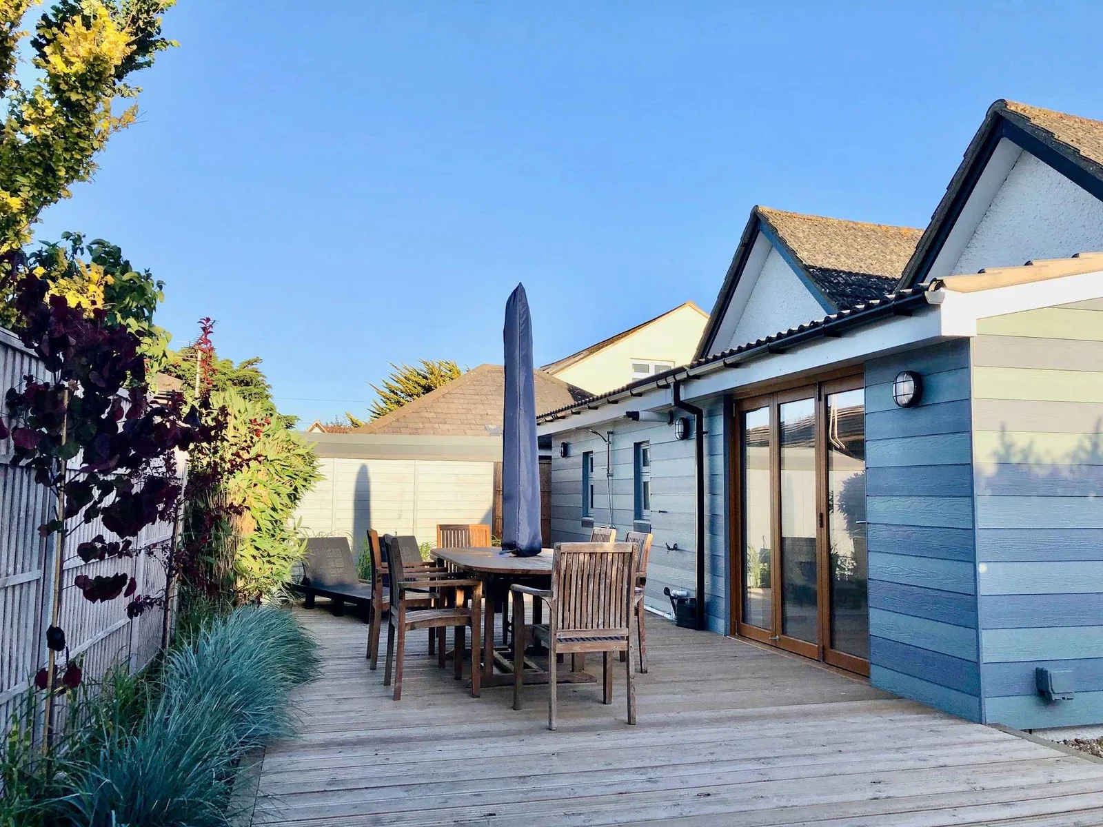 Sunny decked area with outdoor dining, ideal for enjoying meals after a beach day.