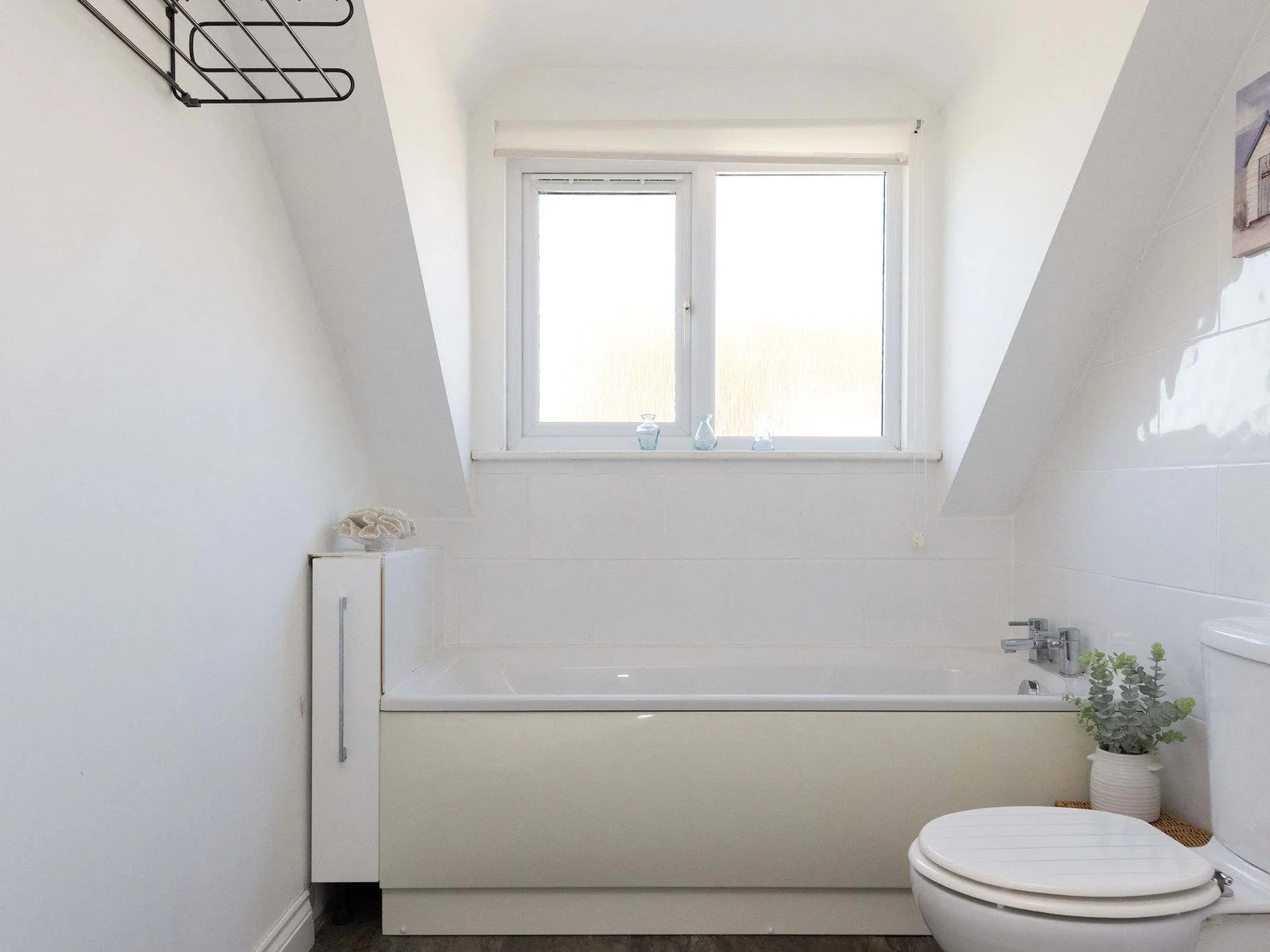 Enjoy a soothing soak in the bright family bathroom of our relaxing coastal retreat.