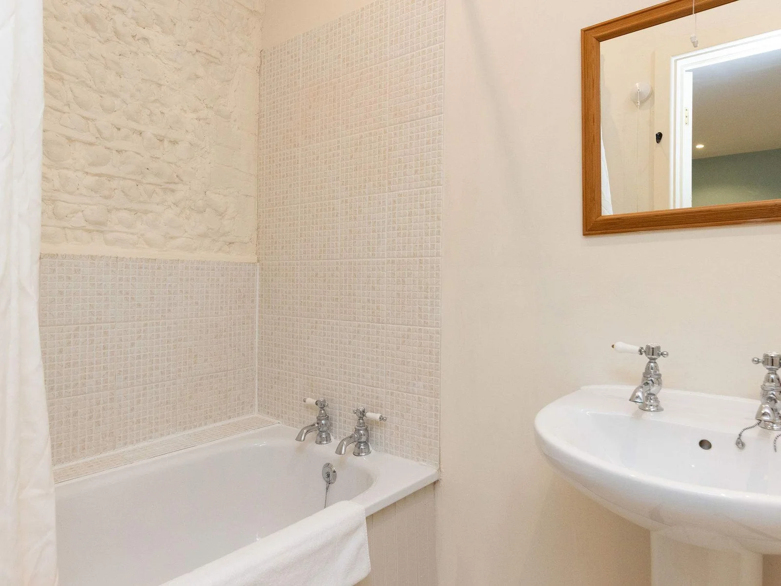 The bathroom has painted exposed brick, continuing the cottage charm.