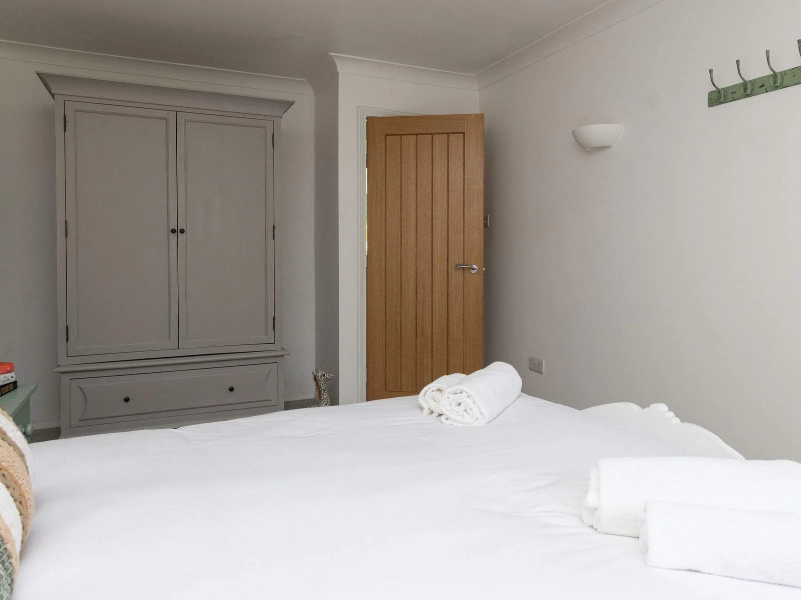 A restful bedroom with practical storage makes settling in easy for short breaks or longer coastal stays.