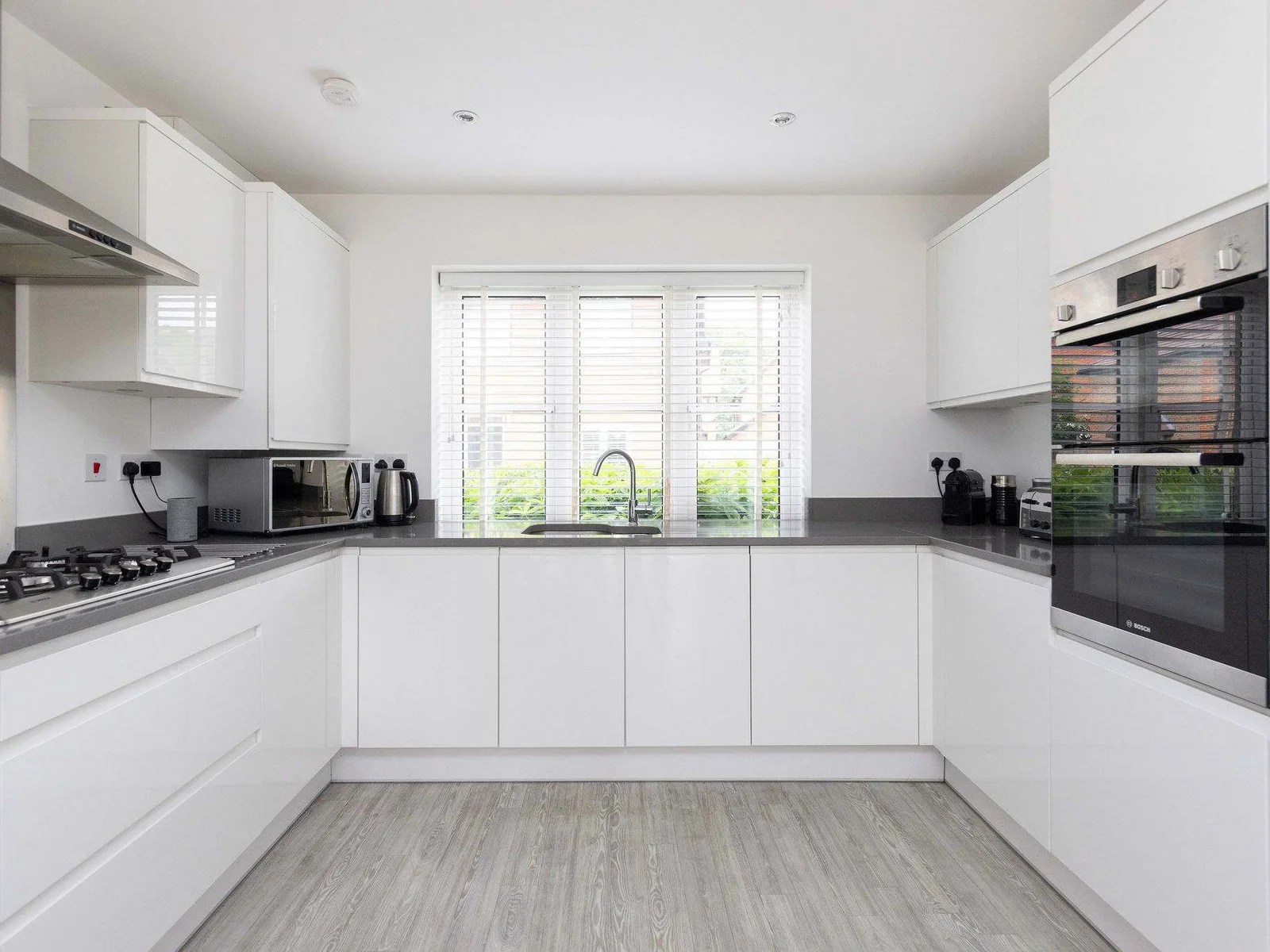 The bright and spacious kitchen is fully equipped with modern appliances, including a double oven and plenty of countertop space.