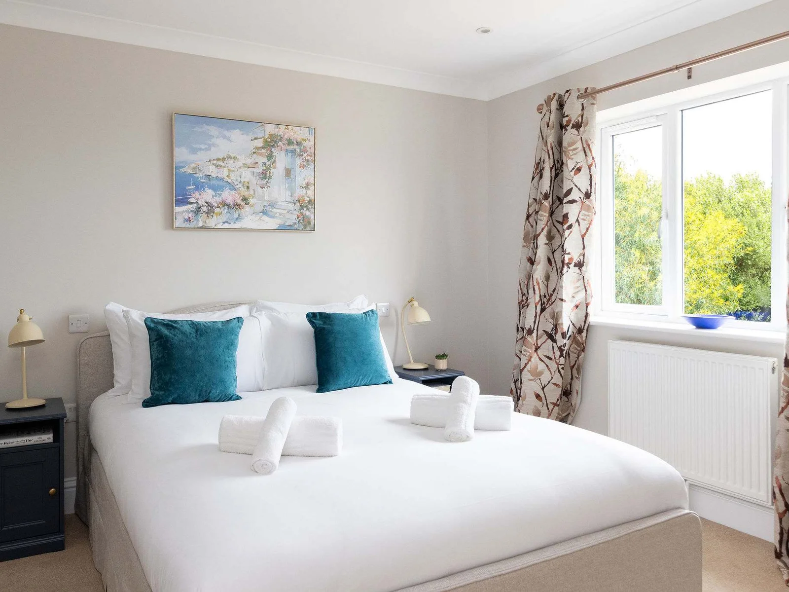 A bright and peaceful double bedroom with leafy views outside — a lovely spot to wake up slowly before heading out for the day.