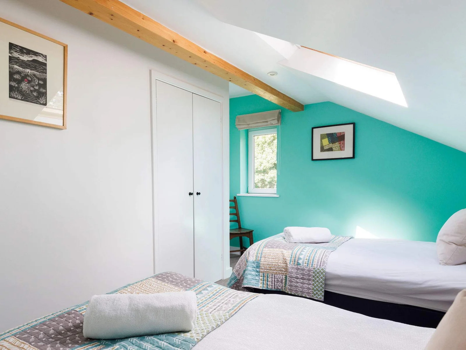 Light and bright twin room, with pops of colour and exposed beams.