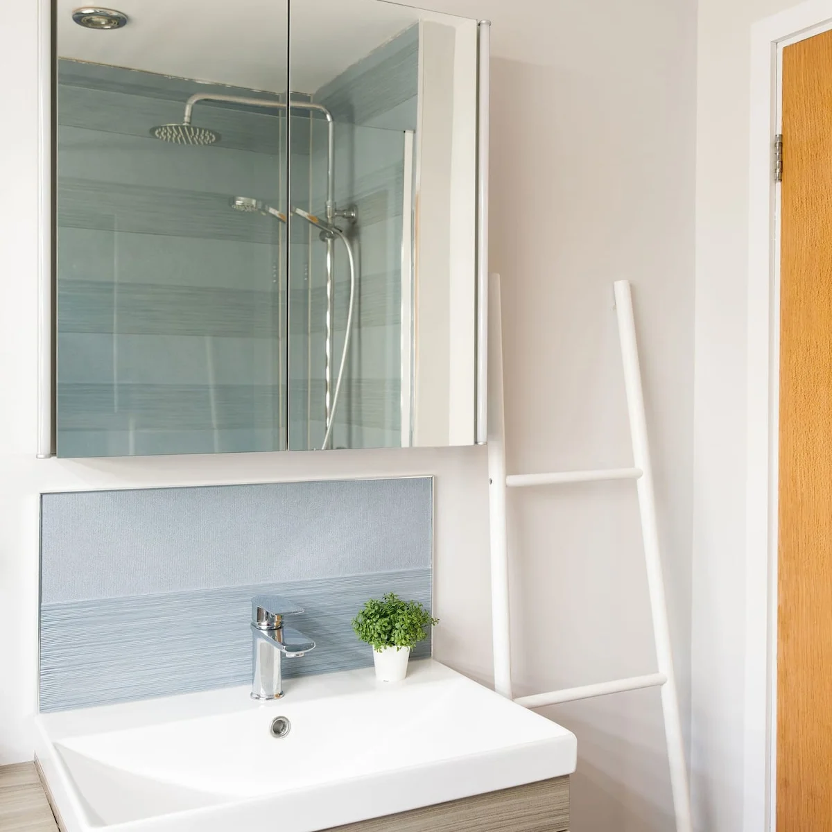 The bathroom sink with overhead mirrored cabinet.