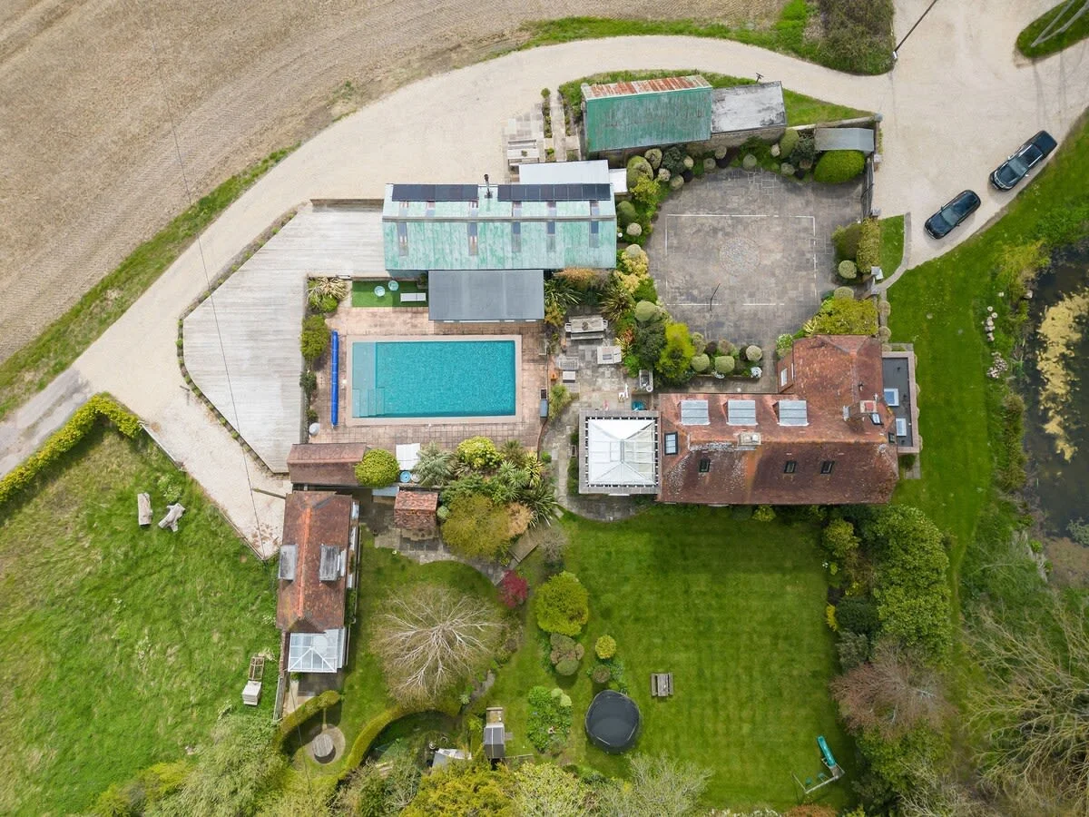 The home has a swimming pool, extensive gardens and patio space, a yoga studio next door and large driveway.