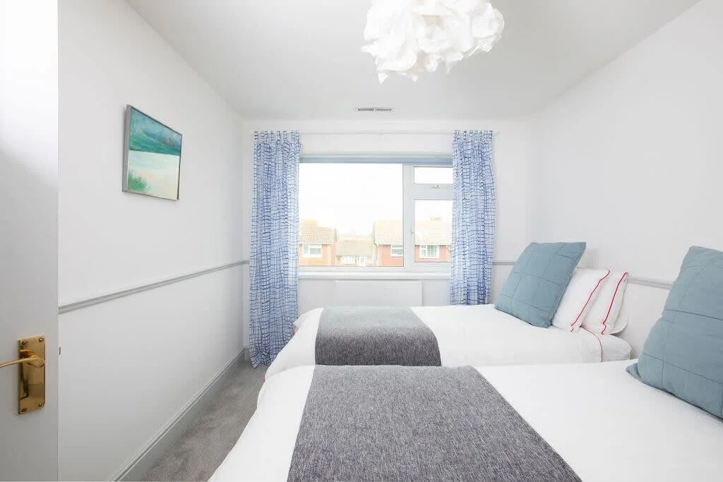 Beautifully-made beds in the twin bedroom.