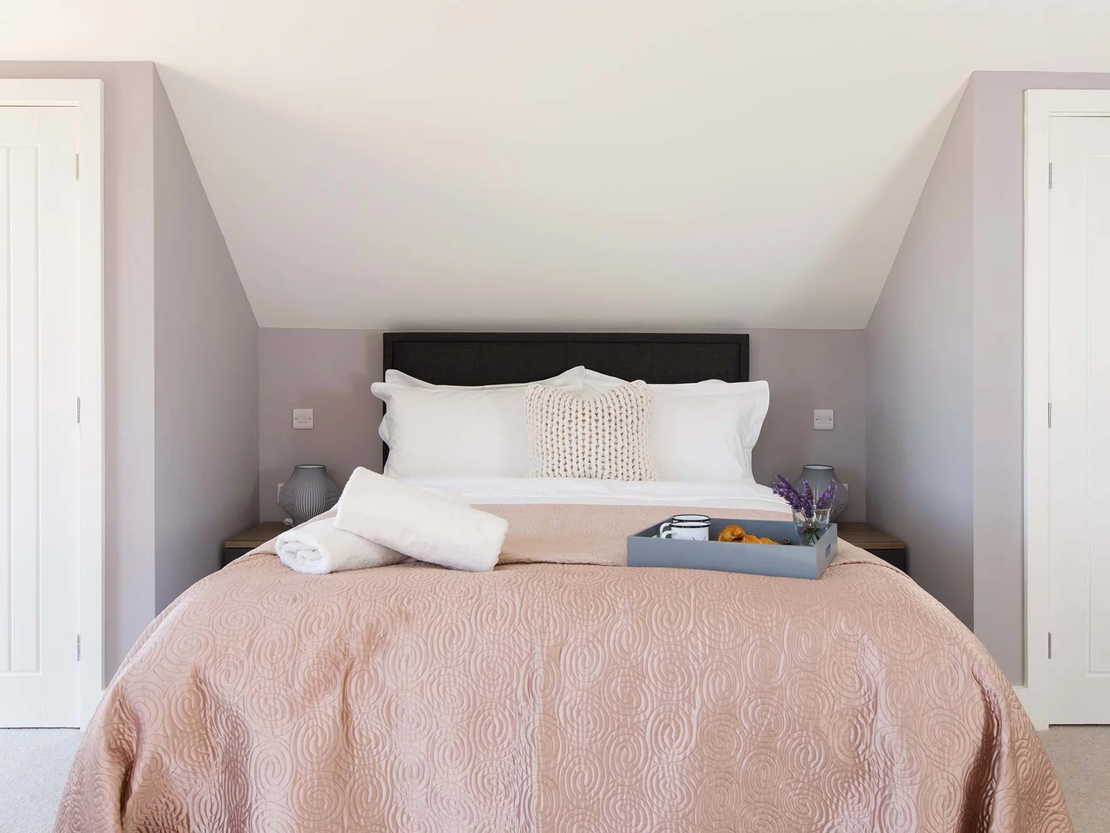 The master bedroom is decorated in soft pinks to create a relaxing space to unwind after a day out exploring this corner of Sussex.