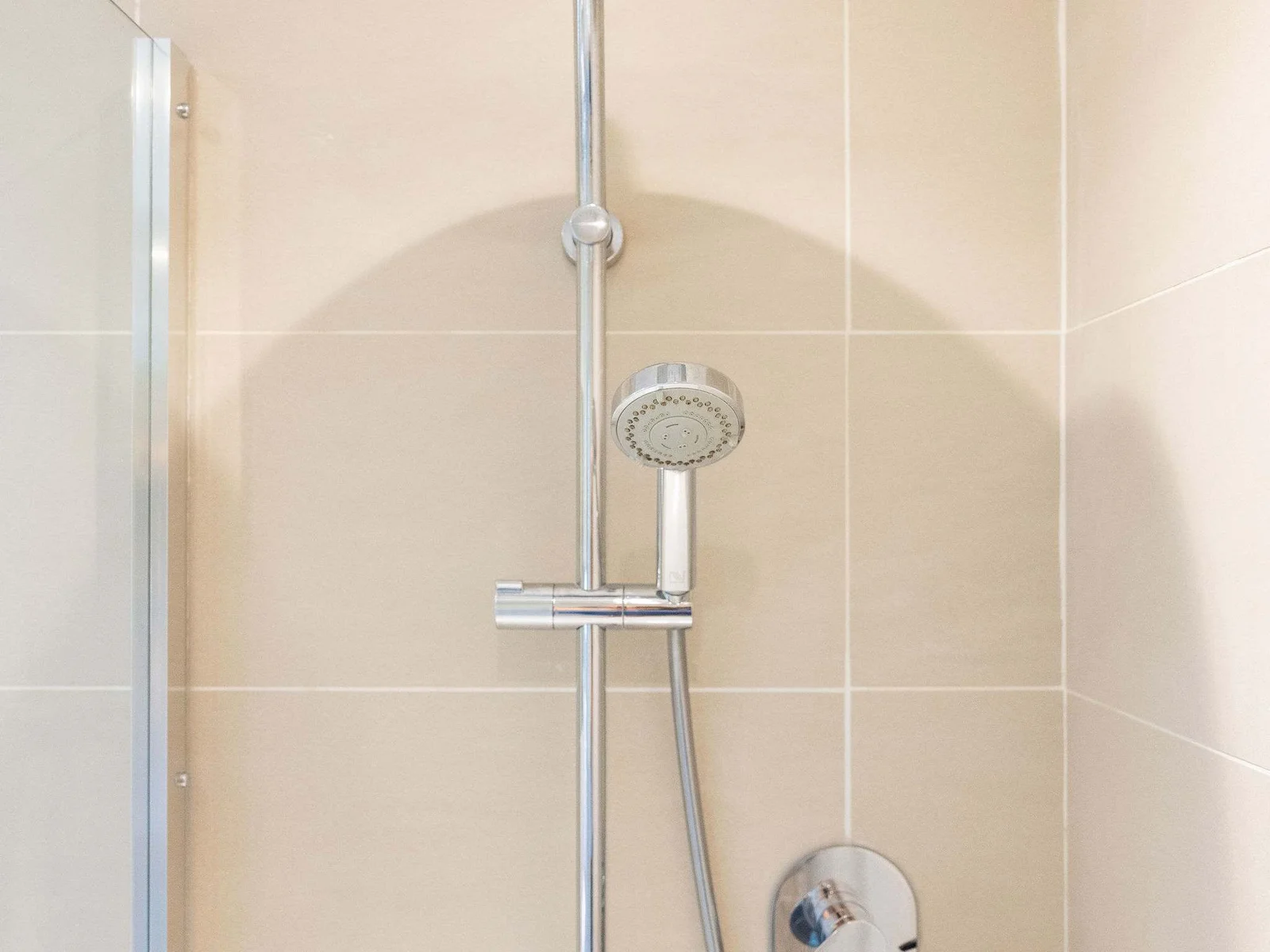 Contemporary shower with an overhead shower head, separate handheld attachment and sleek chrome fittings.