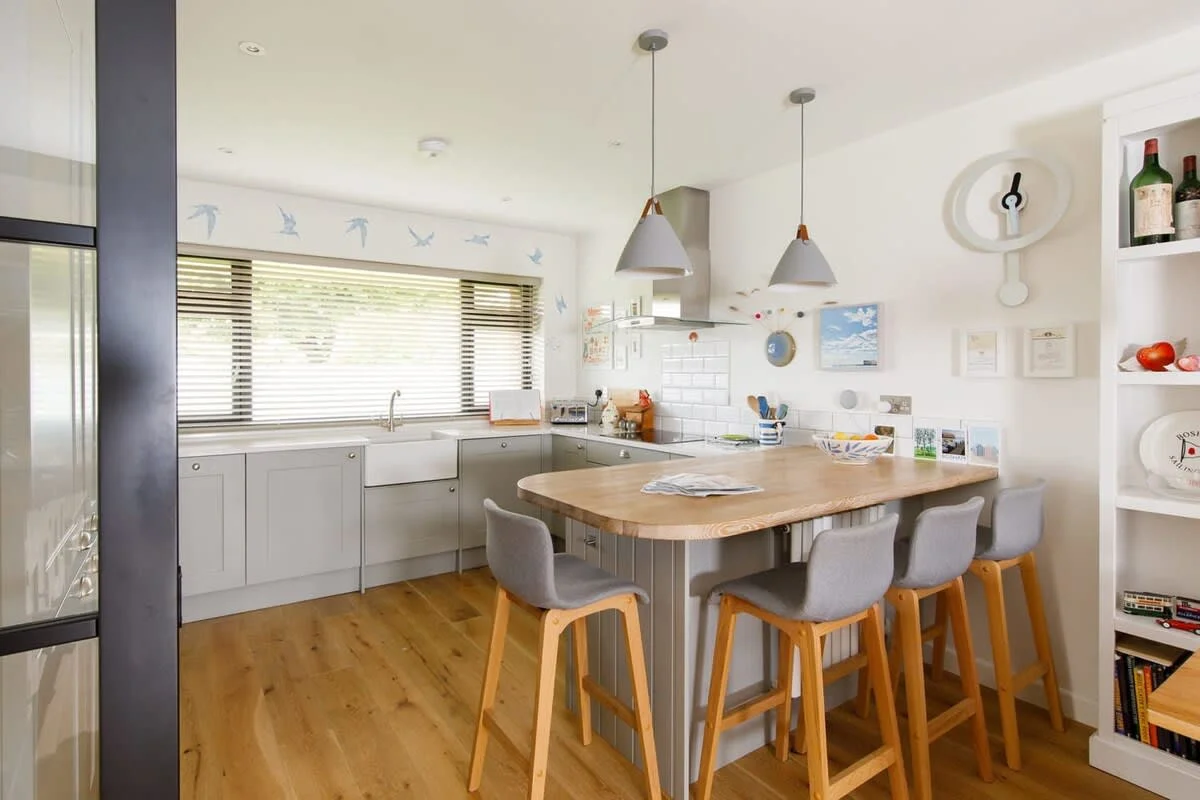 The kitchen is fully equipped with a breakfast bar that seats 4.
