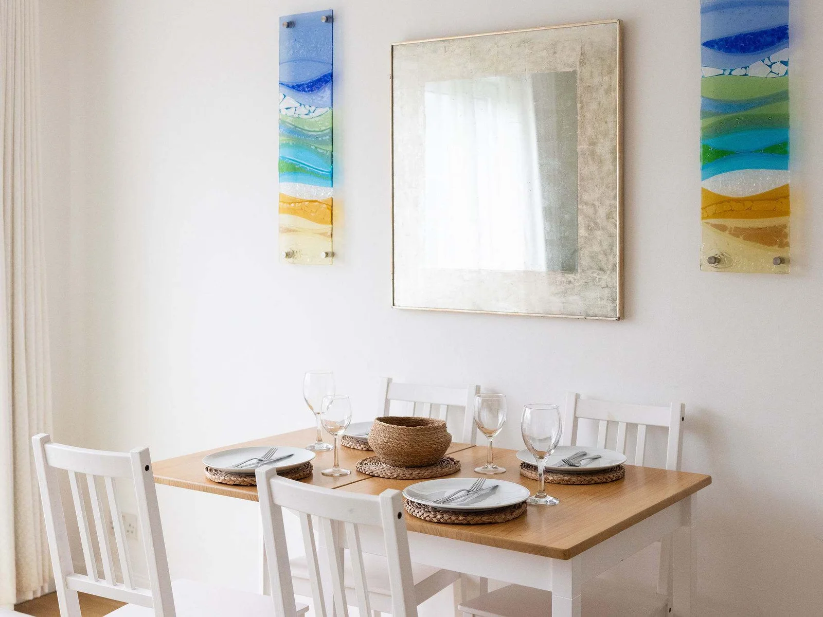 Colourful sea-inspired artwork frames the dining area.