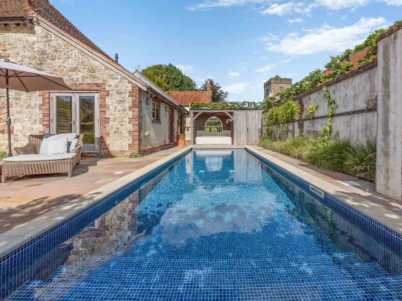 The seasonal private swimming pool, framed by the original stone barn