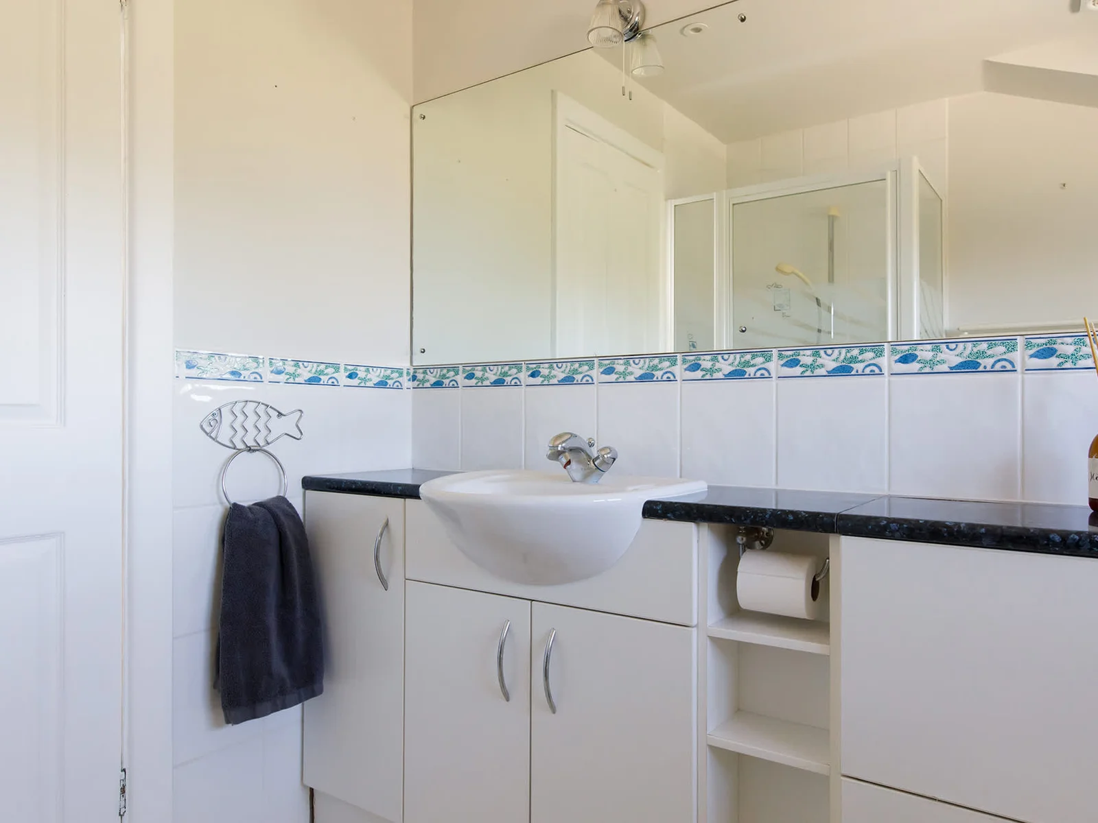The spacious family bathroom has a large mirror, WC, sink and shower.