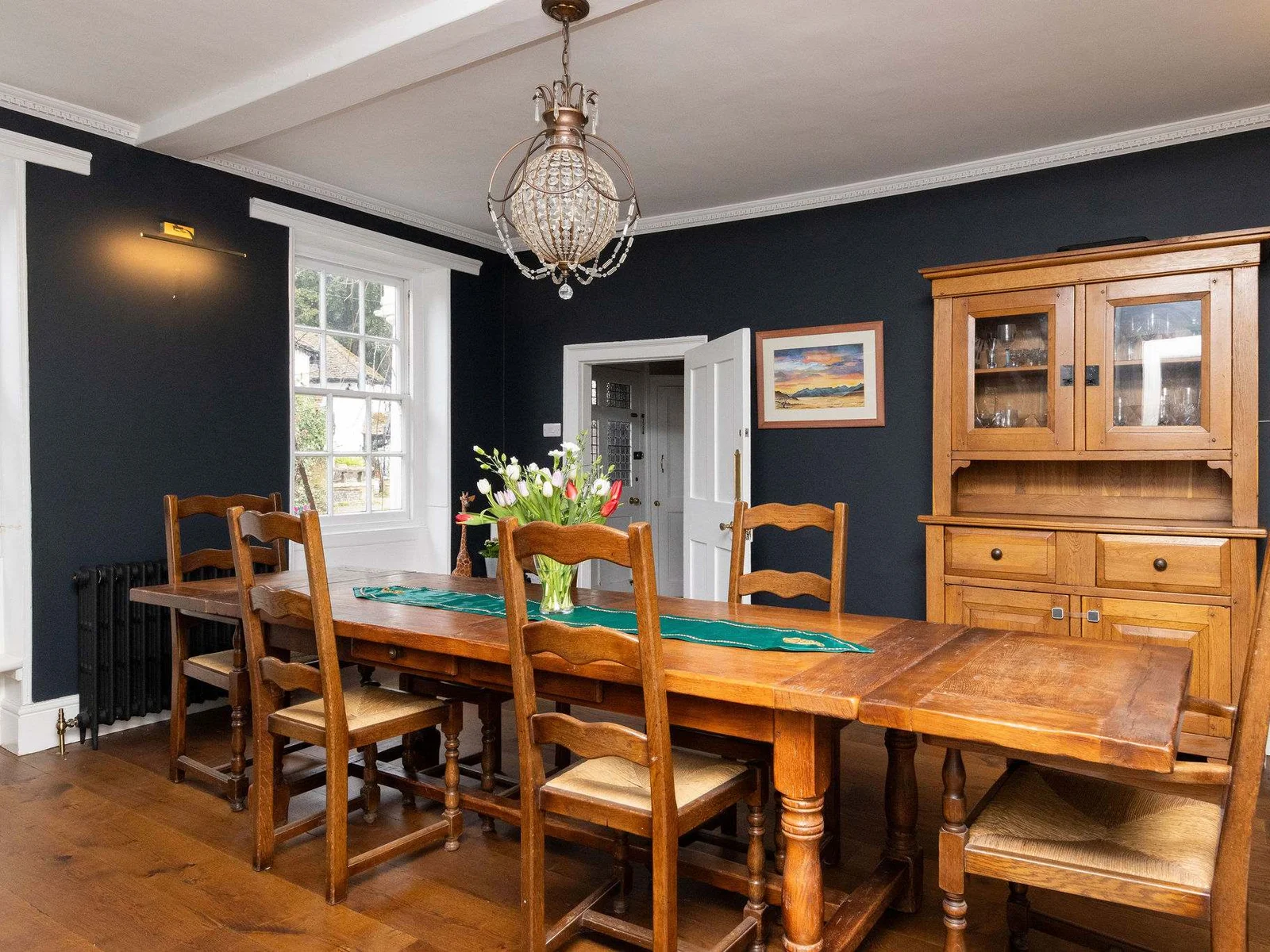 A traditional dining room with wooden furniture and elegant dark walls