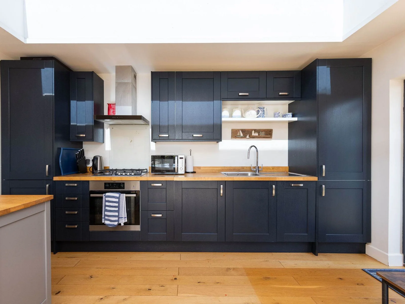 Stylish navy kitchen with warm wood accents, perfect for cooking with your family.