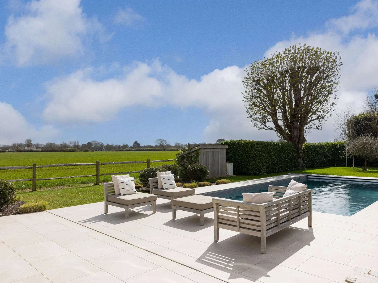 Heated pool surrounded by landscaped gardens and open countryside — perfect for summer relaxation.