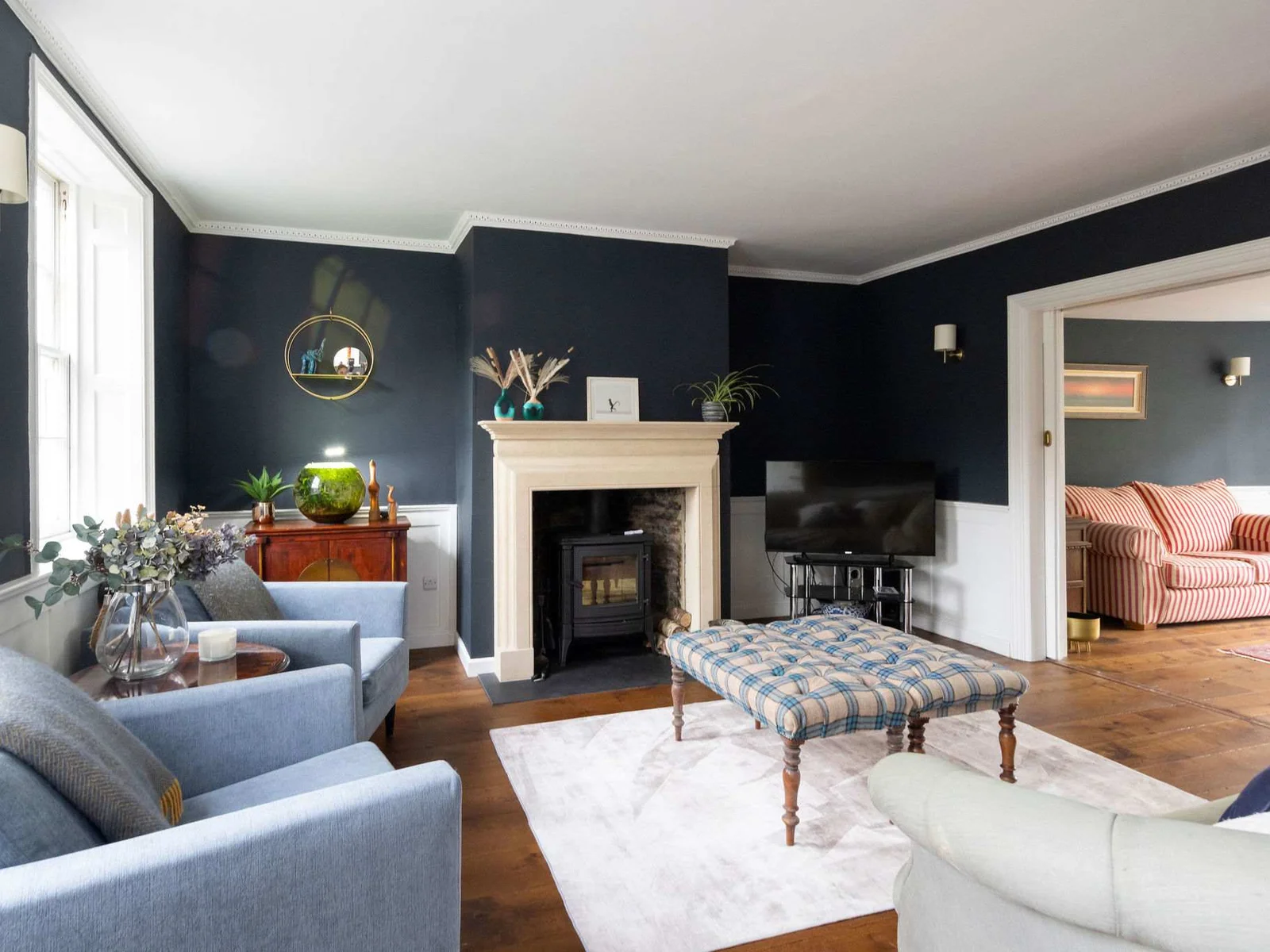 A refined sitting room with a statement log burner and deep blue walls