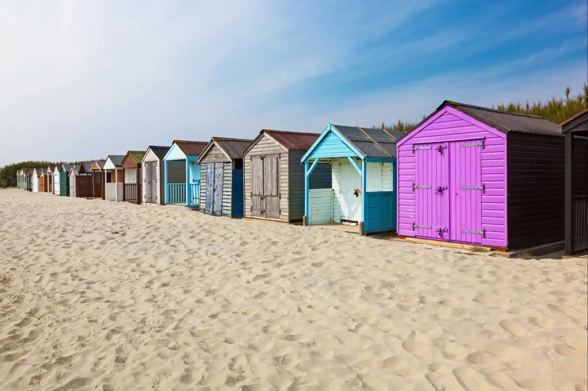 Colourful beach huts at West Wittering's sandy blue flag beach.