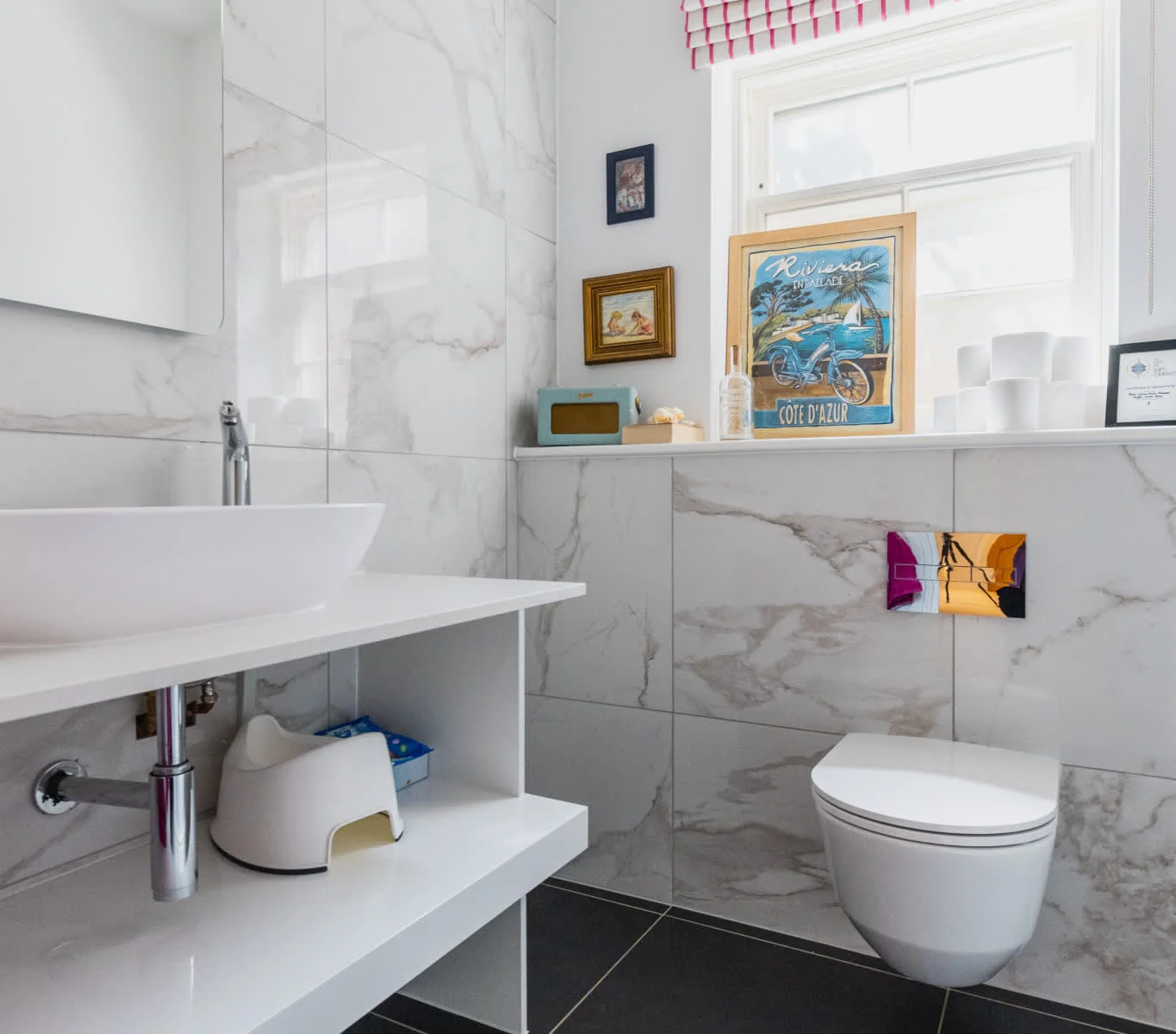 Modern bathroom with marble-style tiles, WC, sink and storage, offering comfort and convenience for guests.