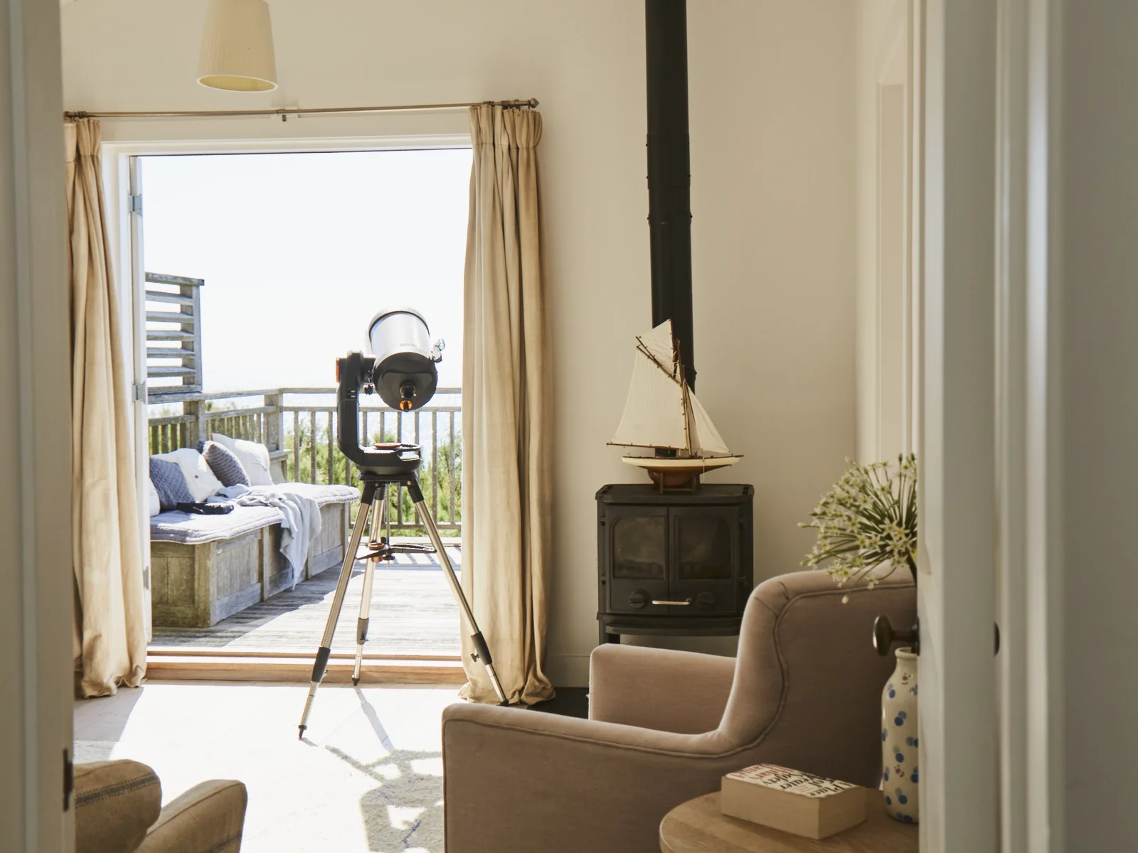 There is a relaxing living area just off the main bedroom. Depending on the time of year, light the log burner or open up the balcony doors to let the sea breeze in.