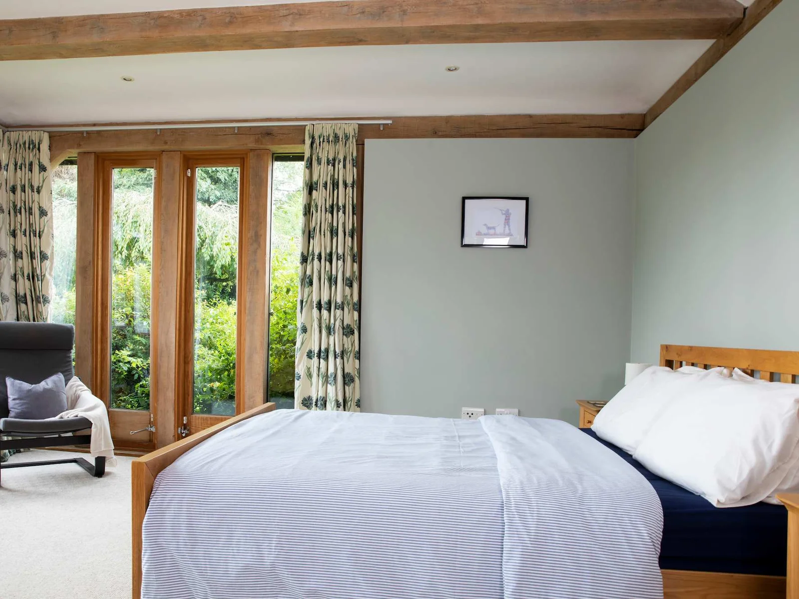 The master bedroom benefits from doors leading out to the garden.