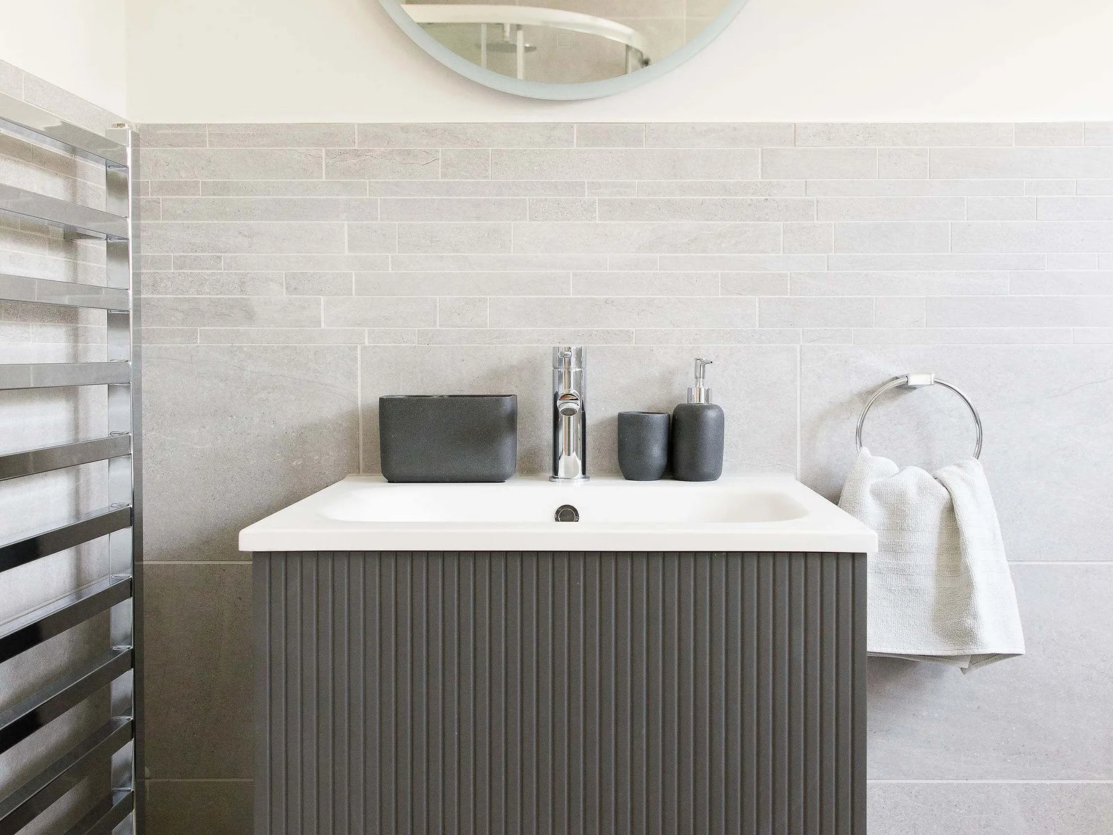 A contemporary sink in the family bathroom with overhead mirror.
