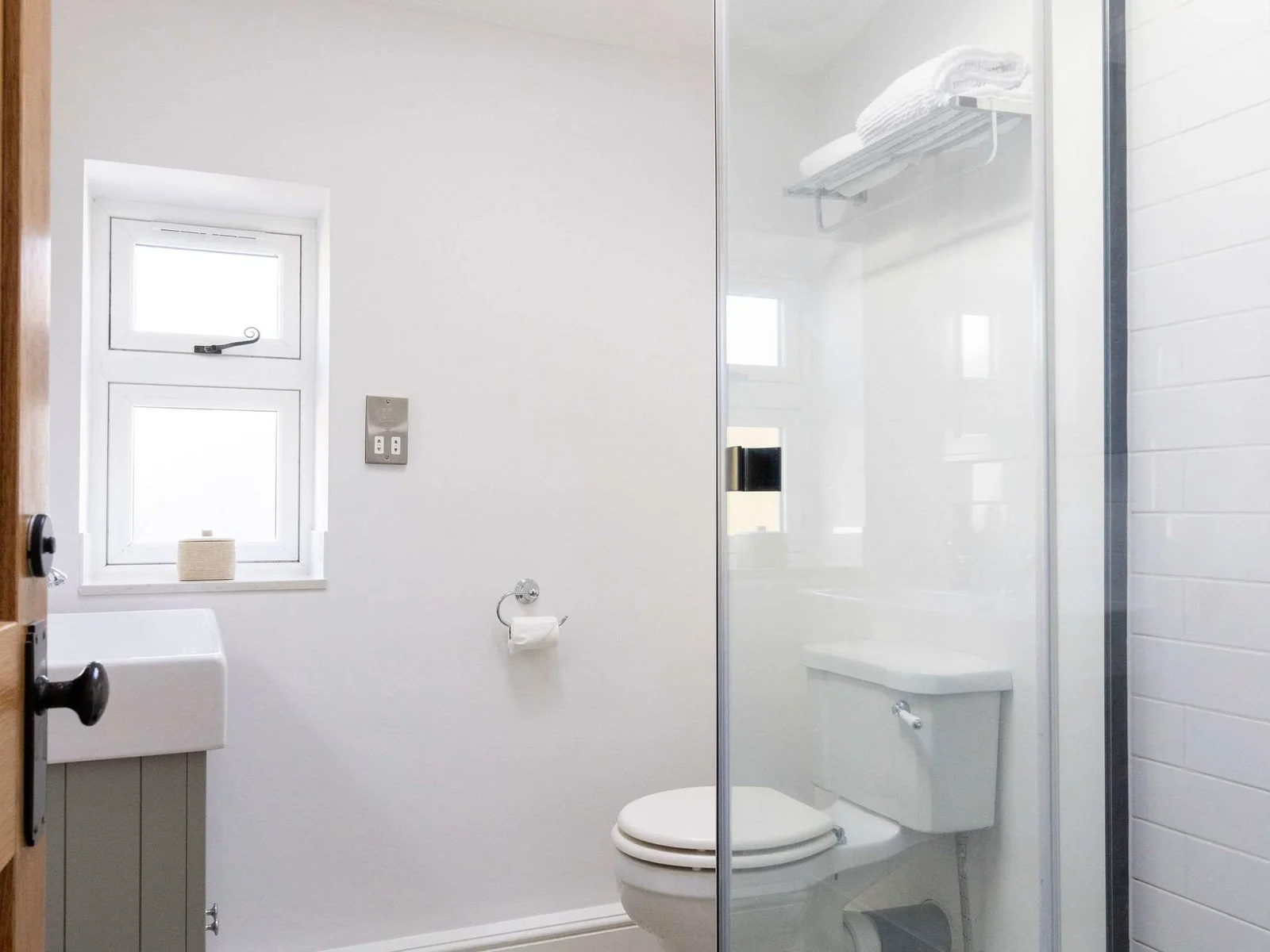 En-suite This bright and modern bathroom features a walk-in shower, toilet, and sink.