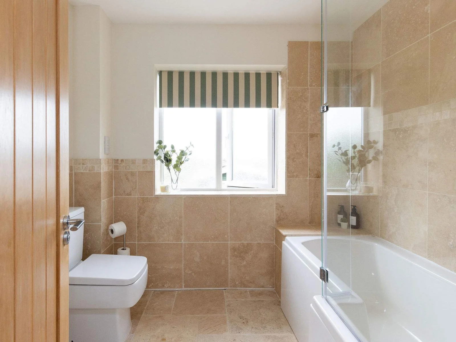 The family bathroom is ideal for easy mornings and post-beach rinses, with a full-size bath, overhead shower and a clean, practical layout for the whole household.