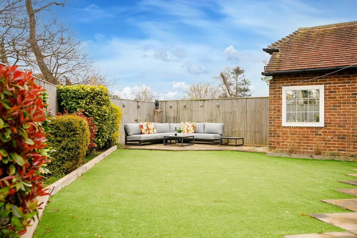 The sunny garden has an artificial grass area for games and a comfy outdoor sofa to relax with a good book or drink.