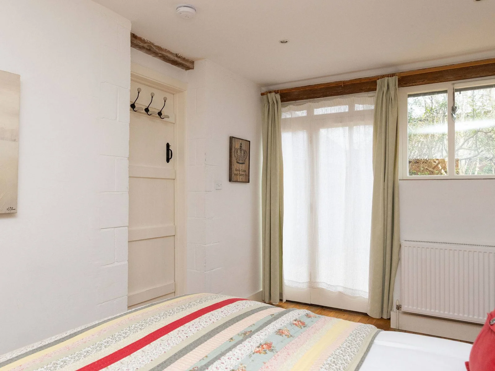 Bright and airy king bedroom with plenty of natural light, storage space and garden views.