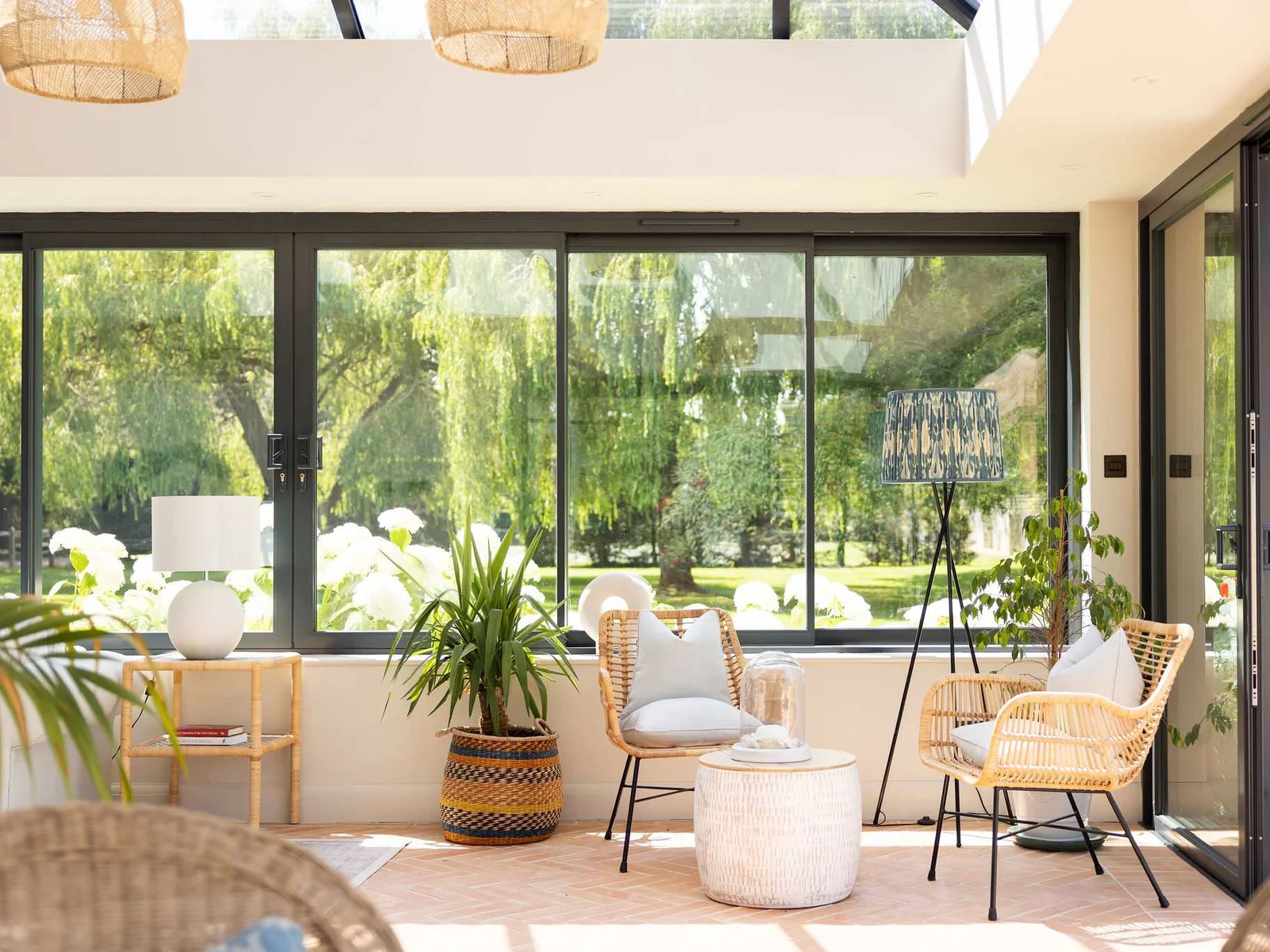 Bright conservatory with garden views, comfortable seating and abundant natural light for peaceful mornings.